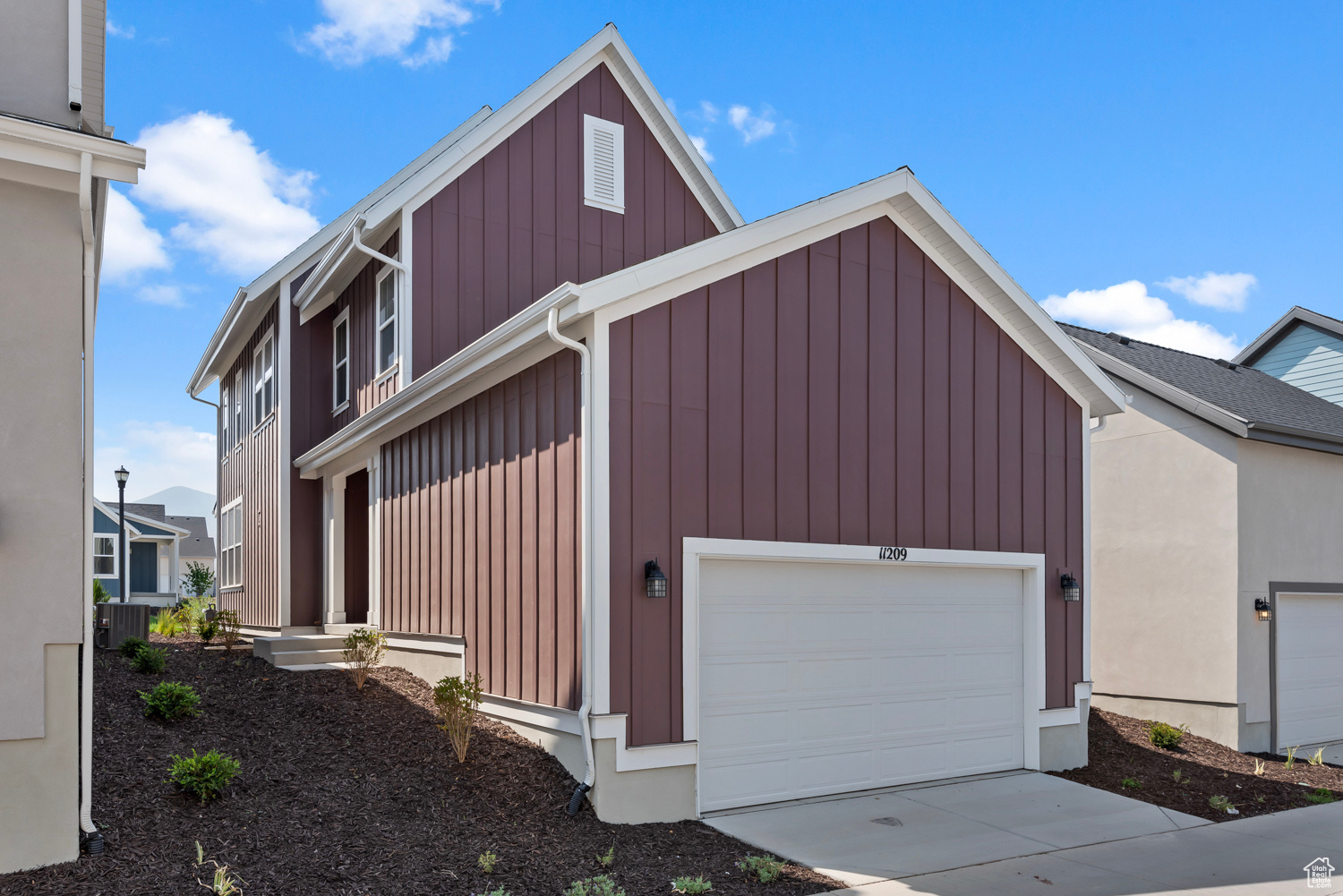 View of side of home with a garage and cooling unit