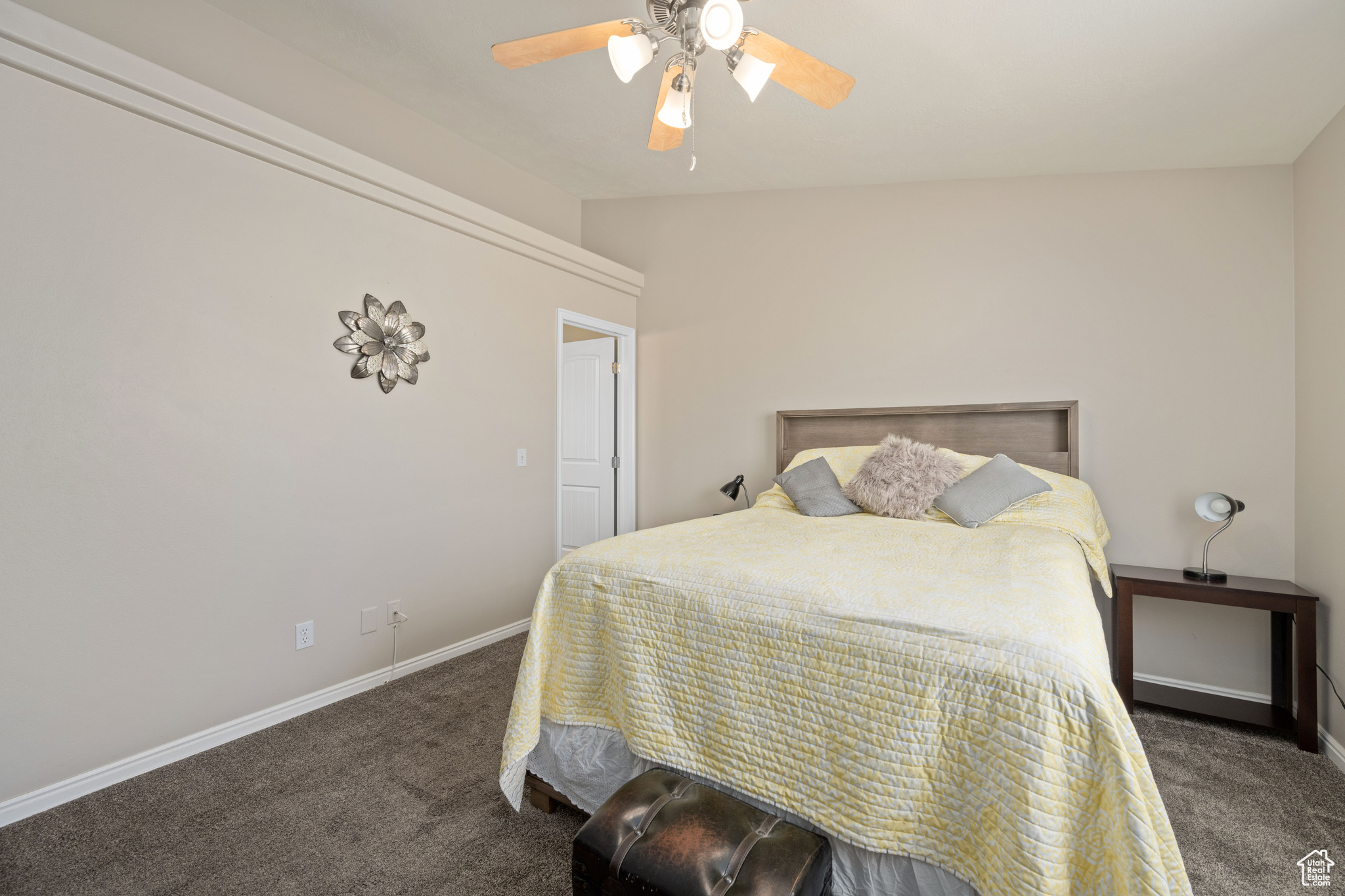 Bedroom with ceiling fan and dark colored carpet