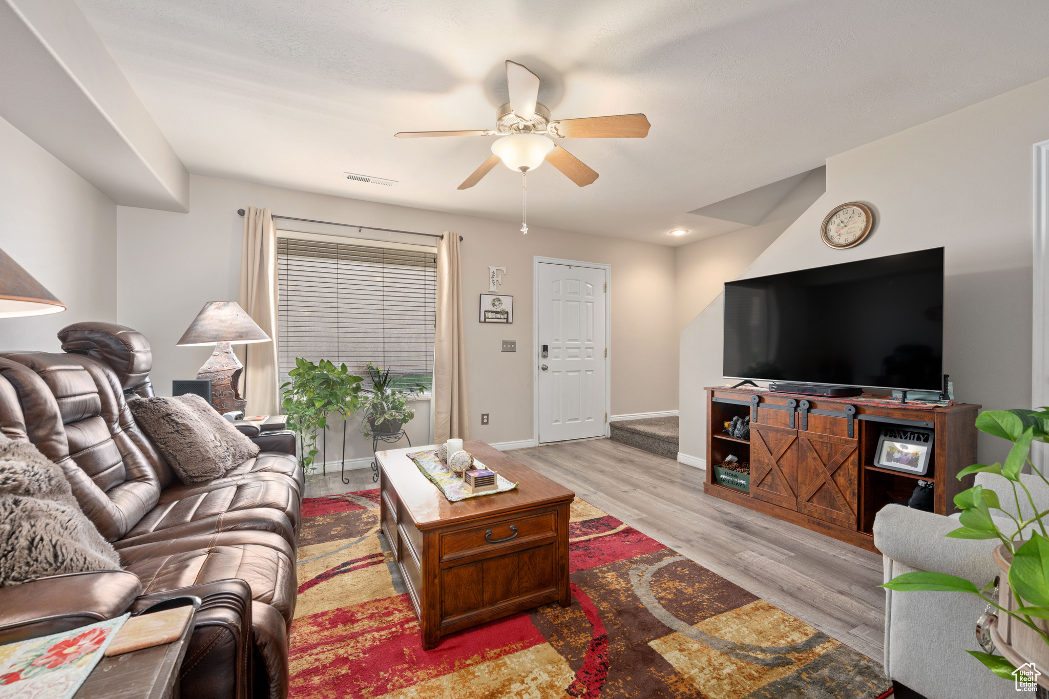 Living room featuring ceiling fan and light hardwood / wood-style flooring