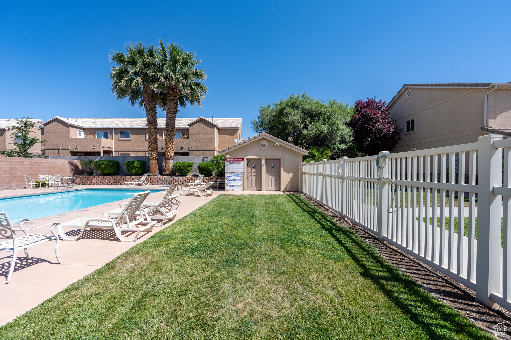 View of swimming pool featuring a yard, an outdoor structure, and a patio area