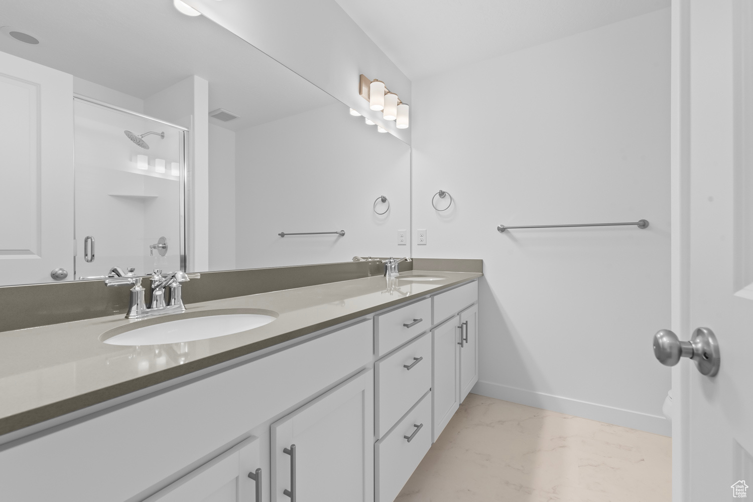 Bathroom with tile floors, double sink, and vanity with extensive cabinet space