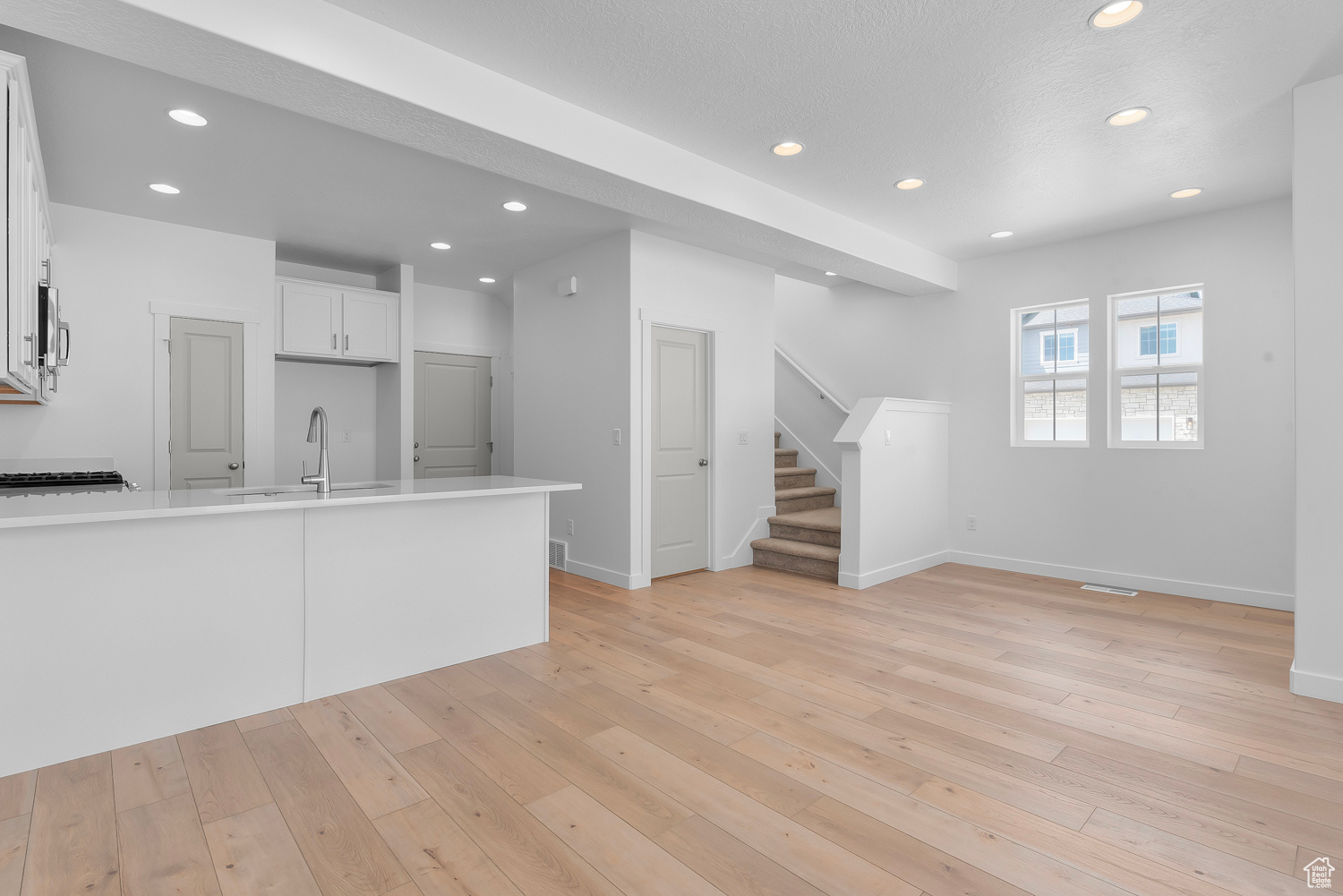 Kitchen featuring white cabinets, sink, and light wood-type flooring