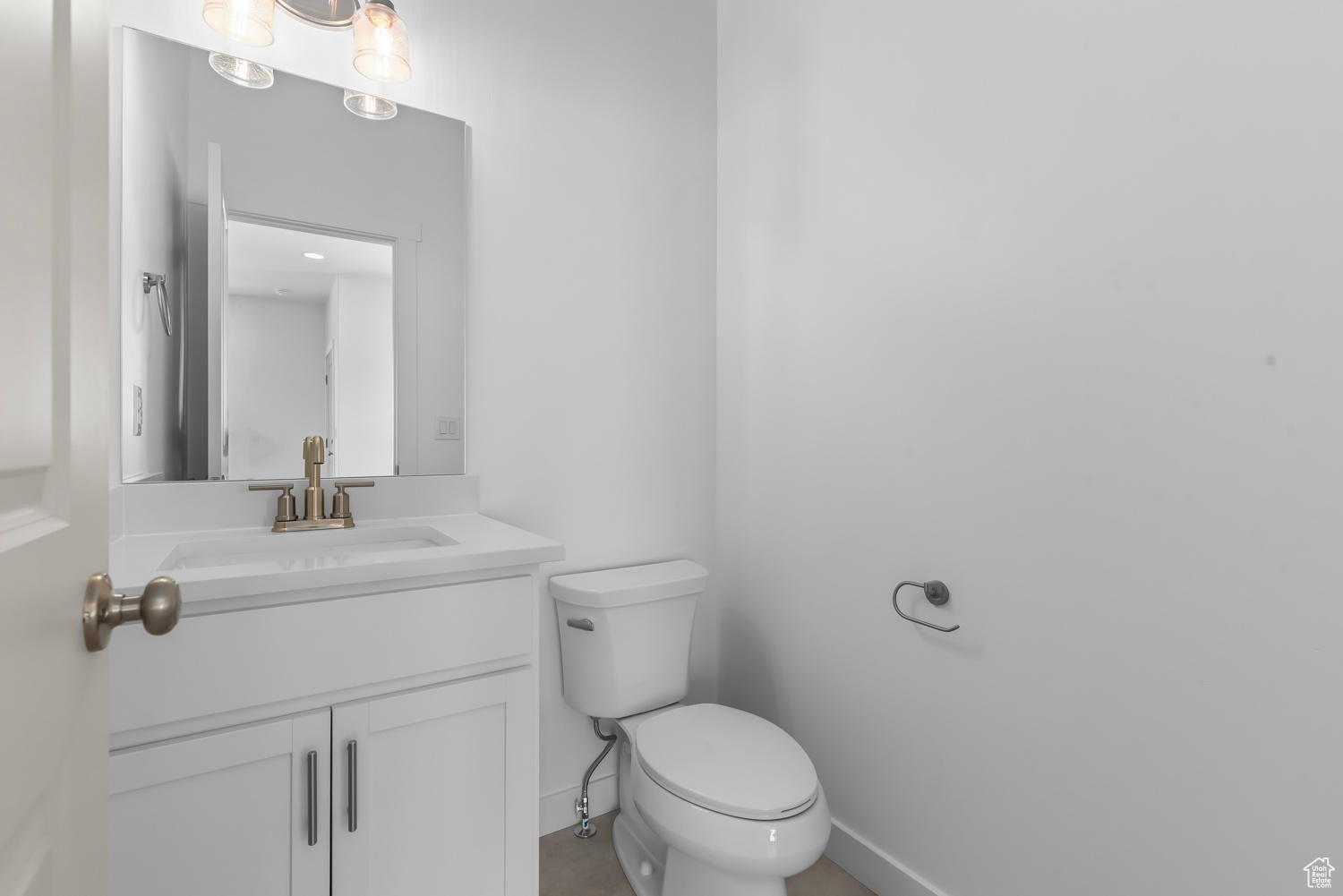 Bathroom with vanity with extensive cabinet space and toilet