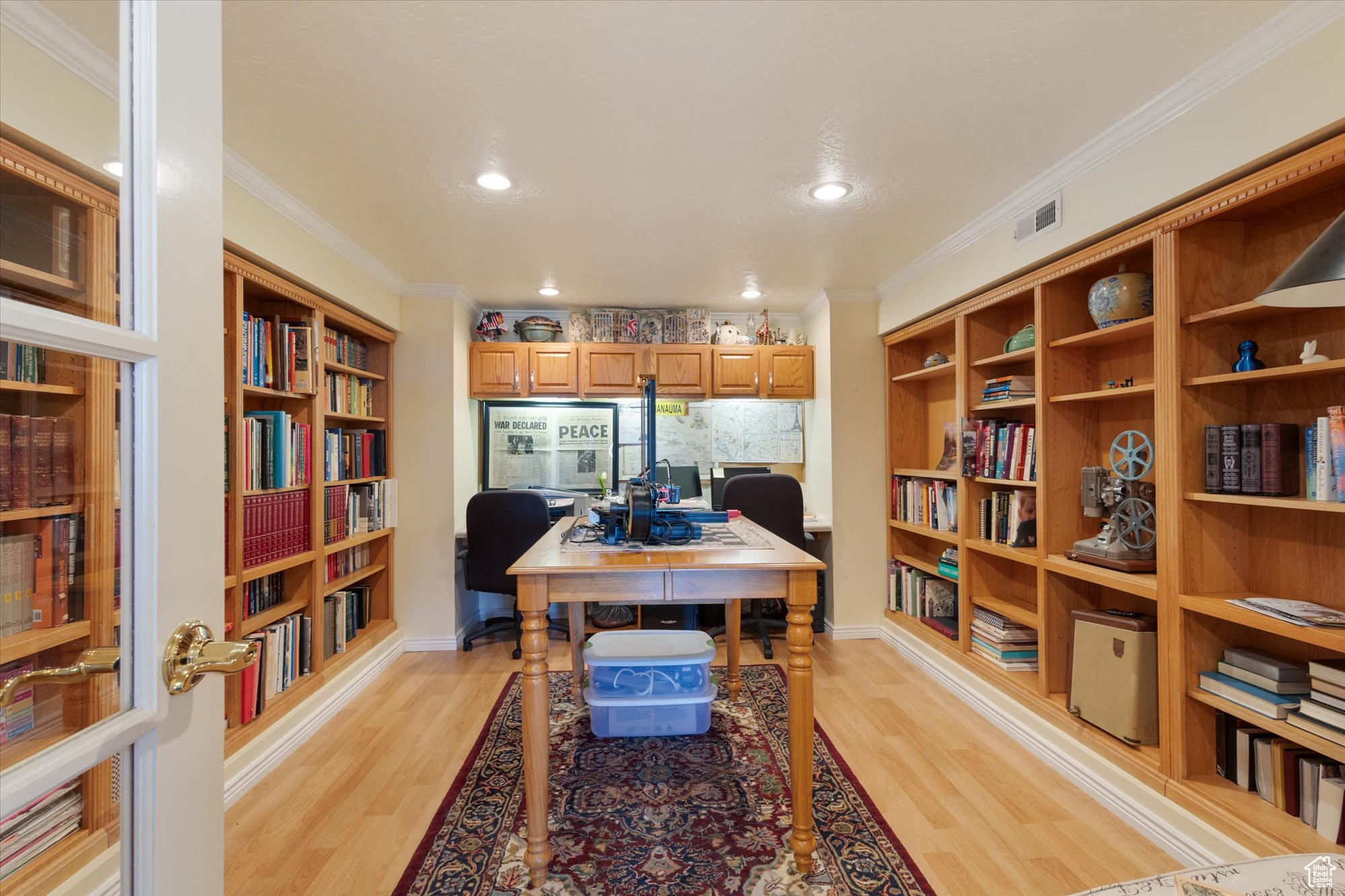 Office/library area featuring crown molding, built in features, and light hardwood / wood-style flooring