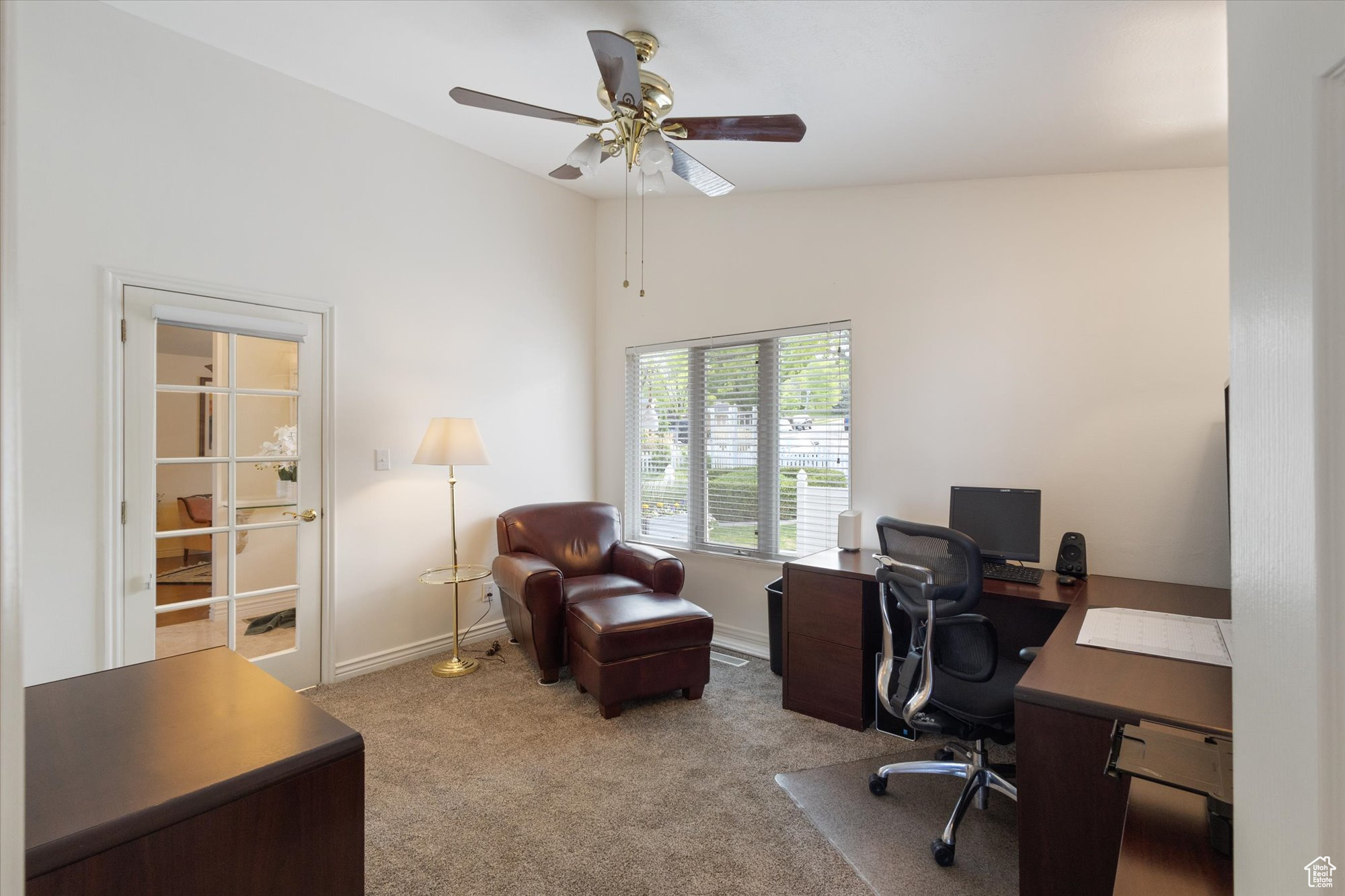 Carpeted home office featuring ceiling fan and vaulted ceiling