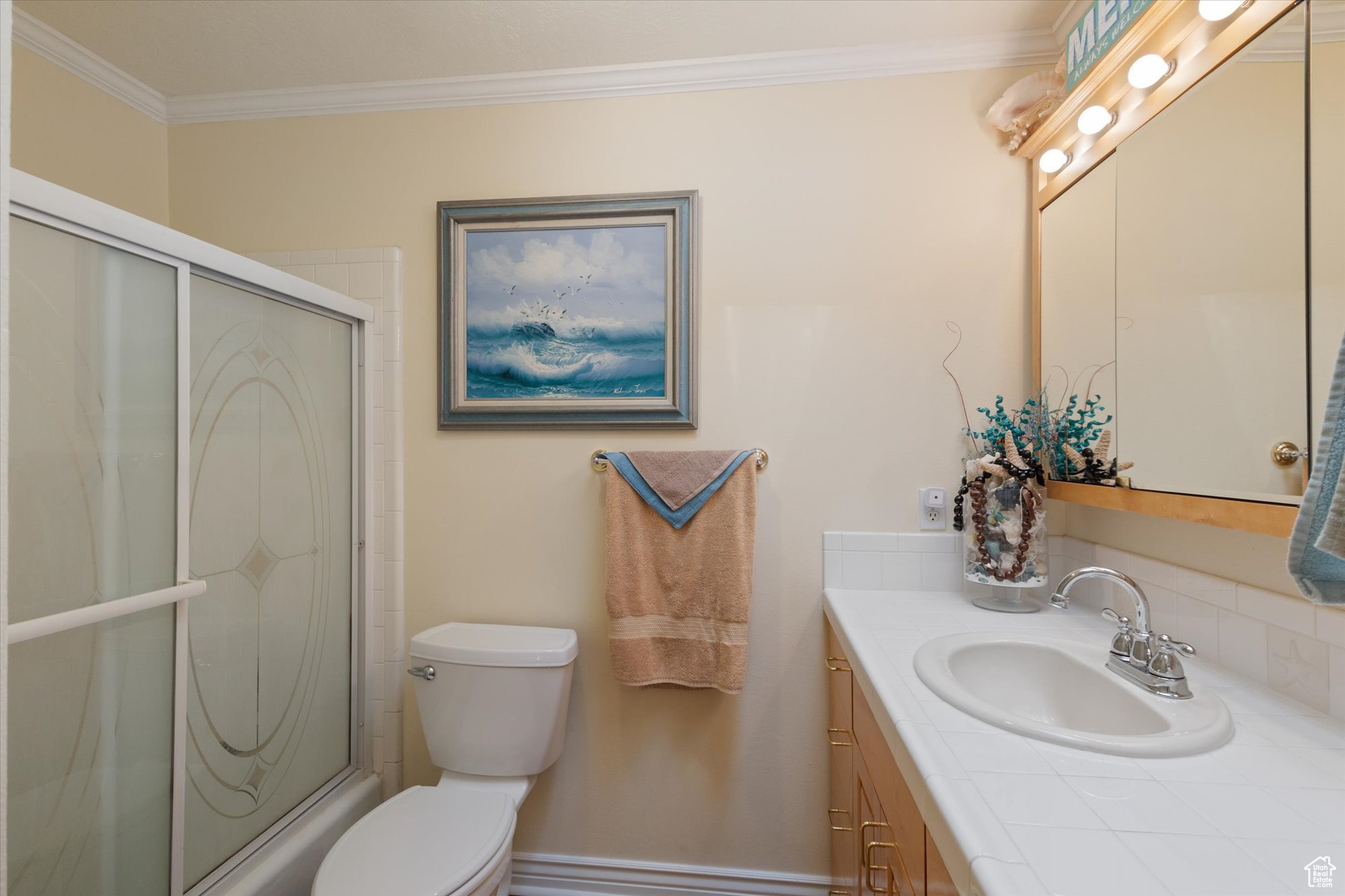 Bathroom with vanity, toilet, and ornamental molding