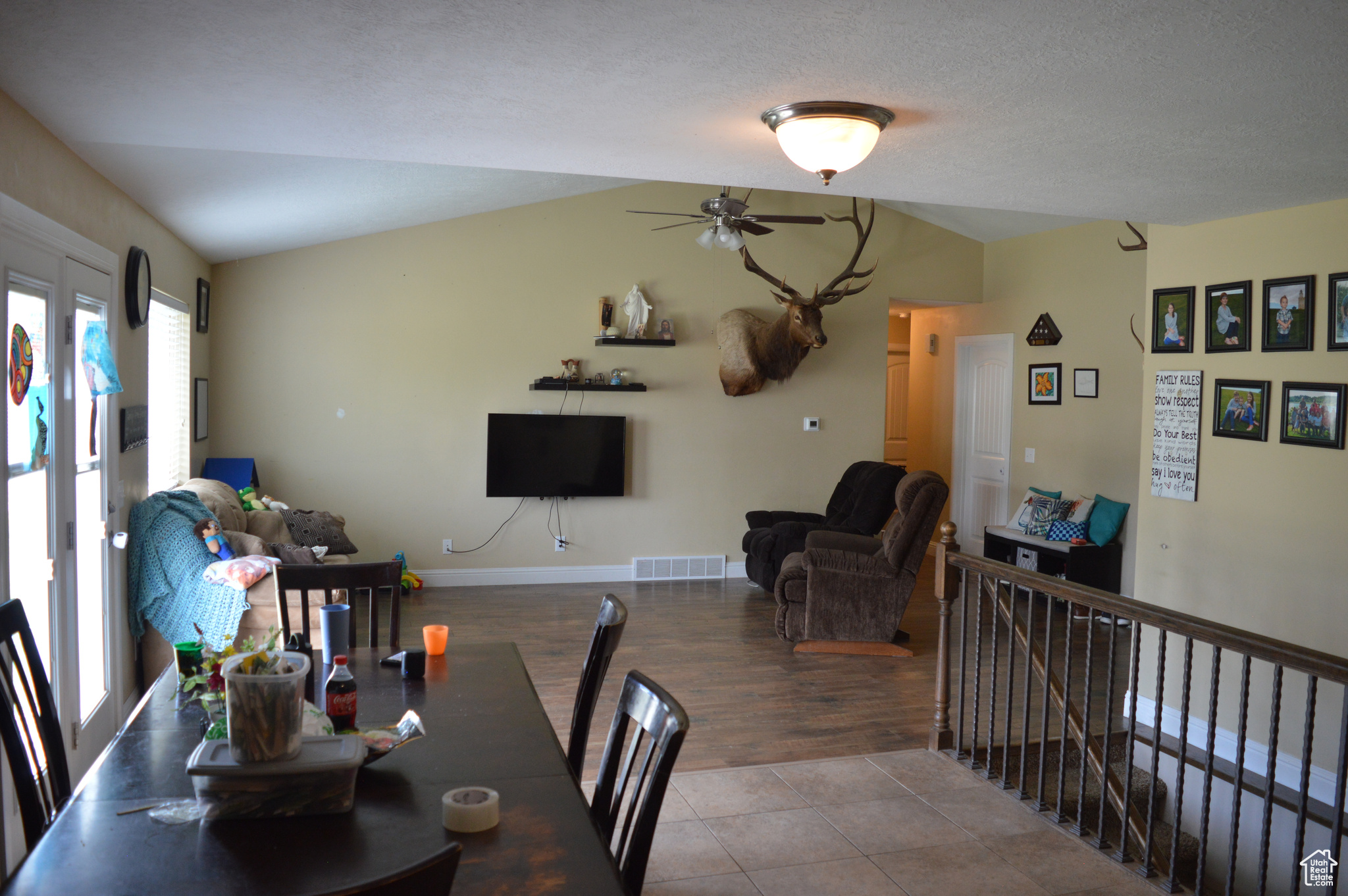 Tiled dining area with ceiling fan, a textured ceiling, and lofted ceiling