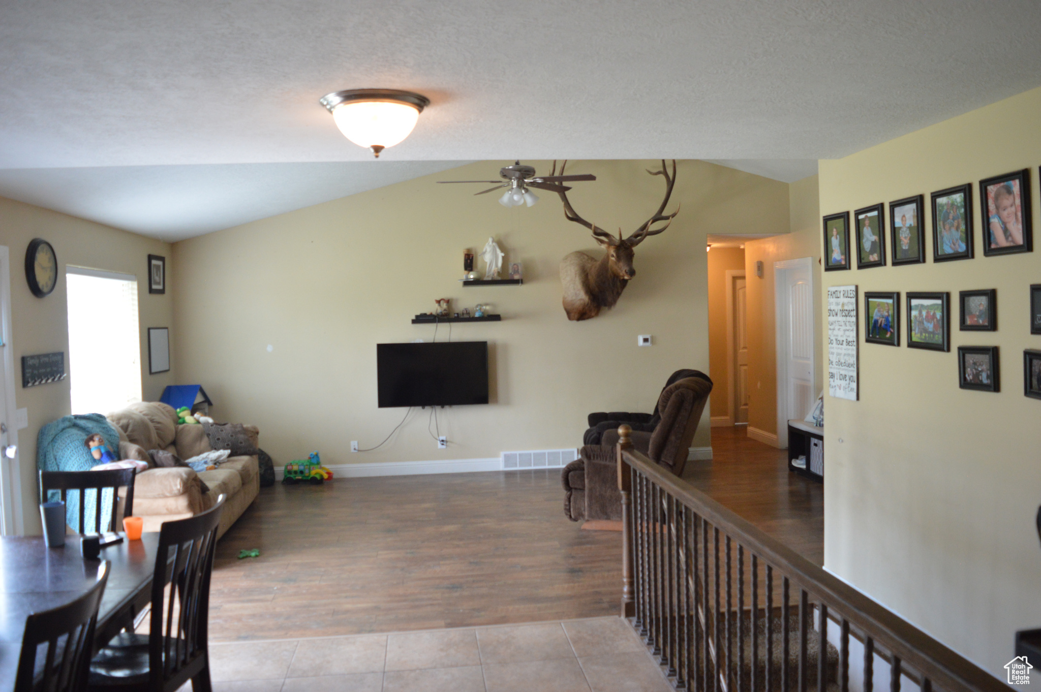 Tiled living room with ceiling fan and a textured ceiling