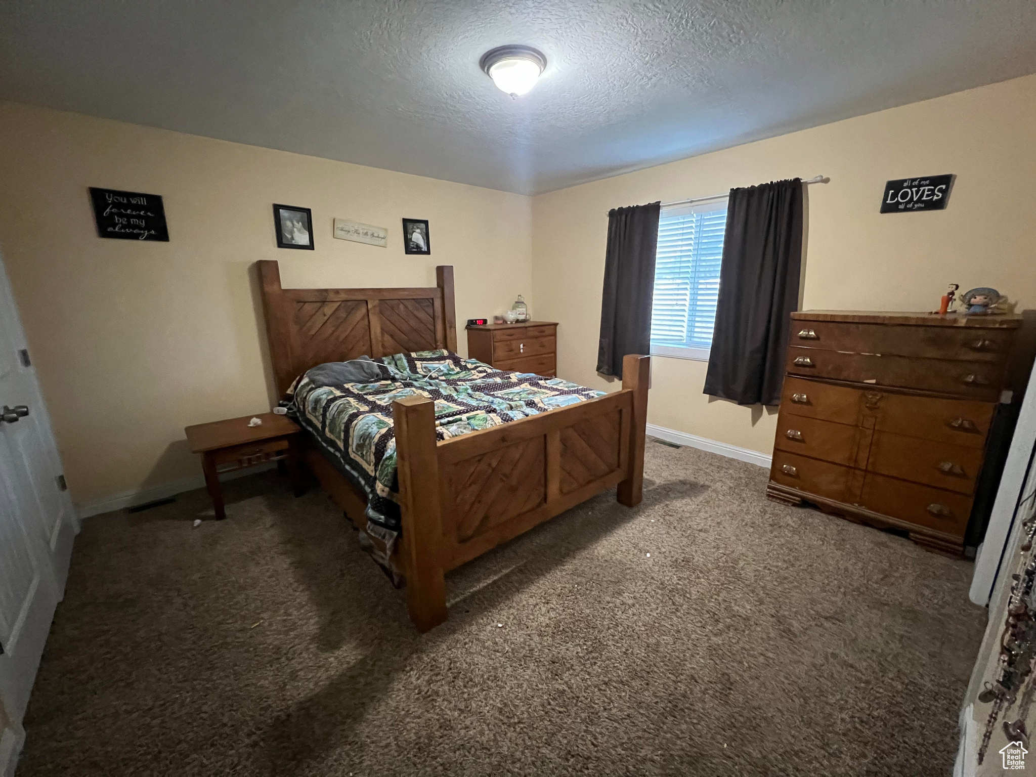 Bedroom featuring dark colored carpet and a textured ceiling