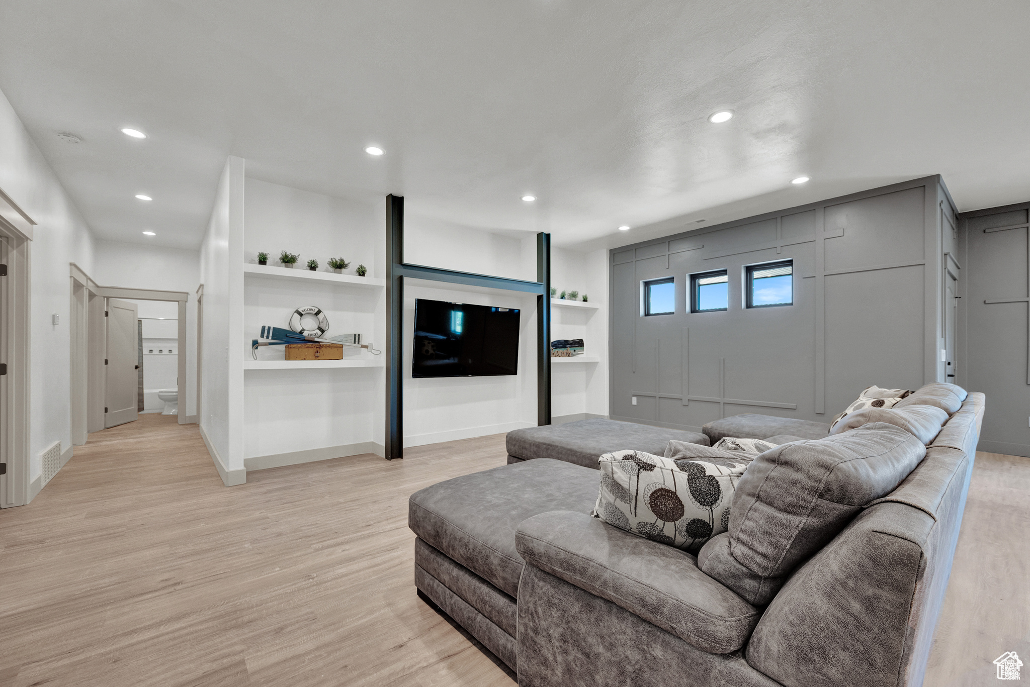 Living room featuring light hardwood / wood-style floors and built in shelves