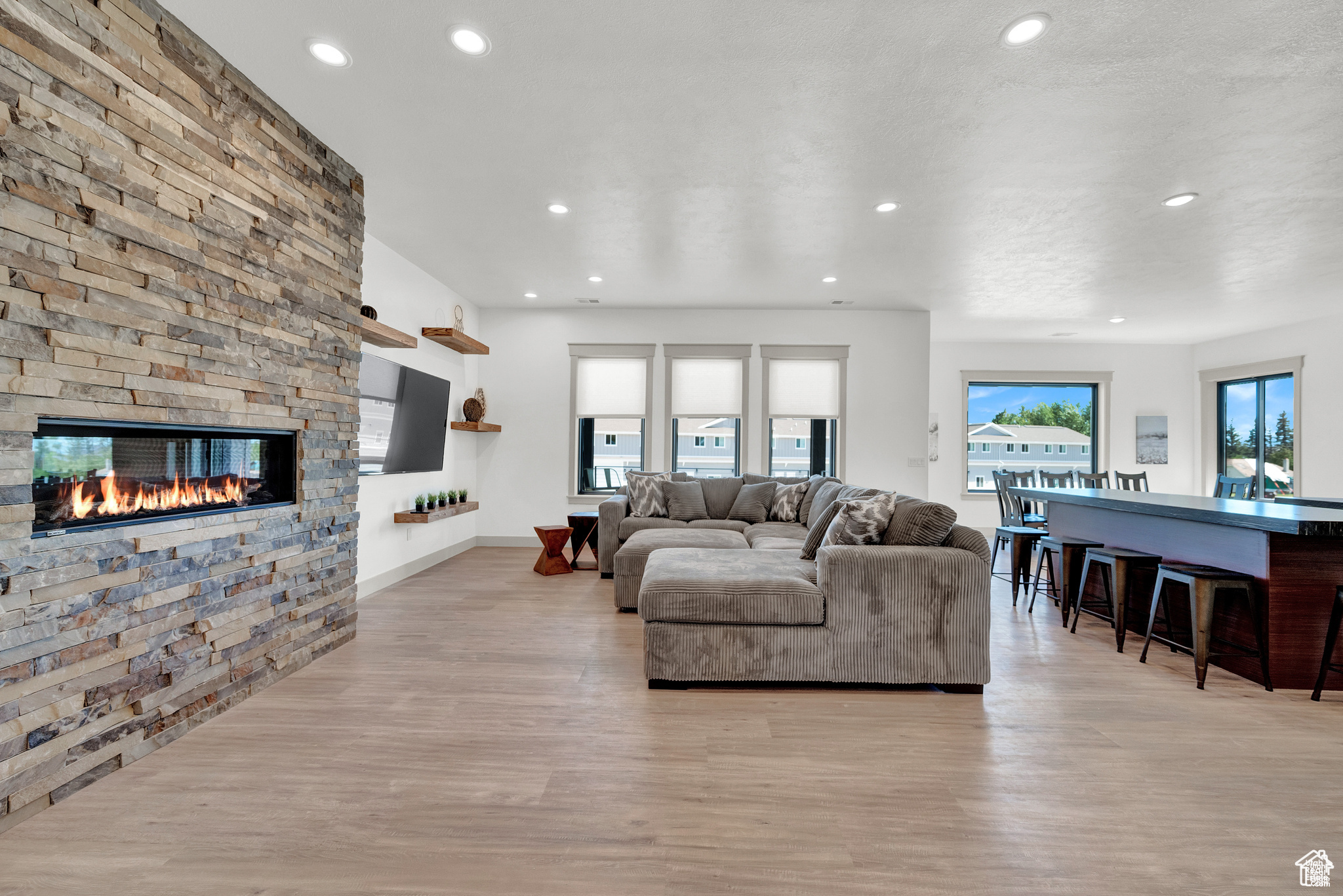 Living room featuring a stone fireplace and light hardwood / wood-style flooring