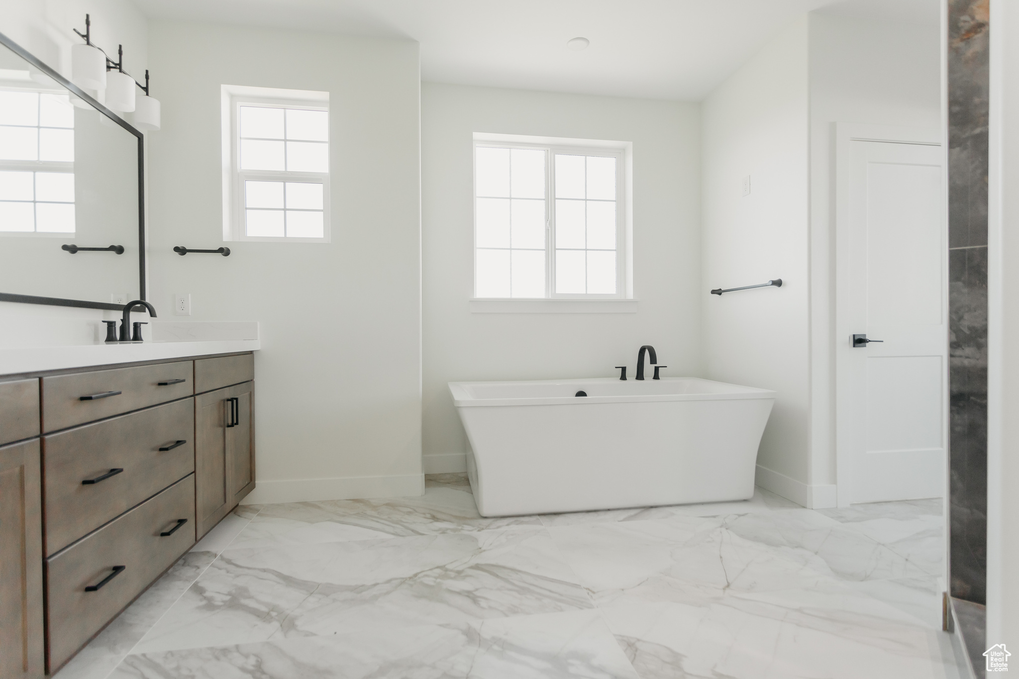 Primary bedroom bathroom with tile flooring, a large soaking tub, and oversized vanity