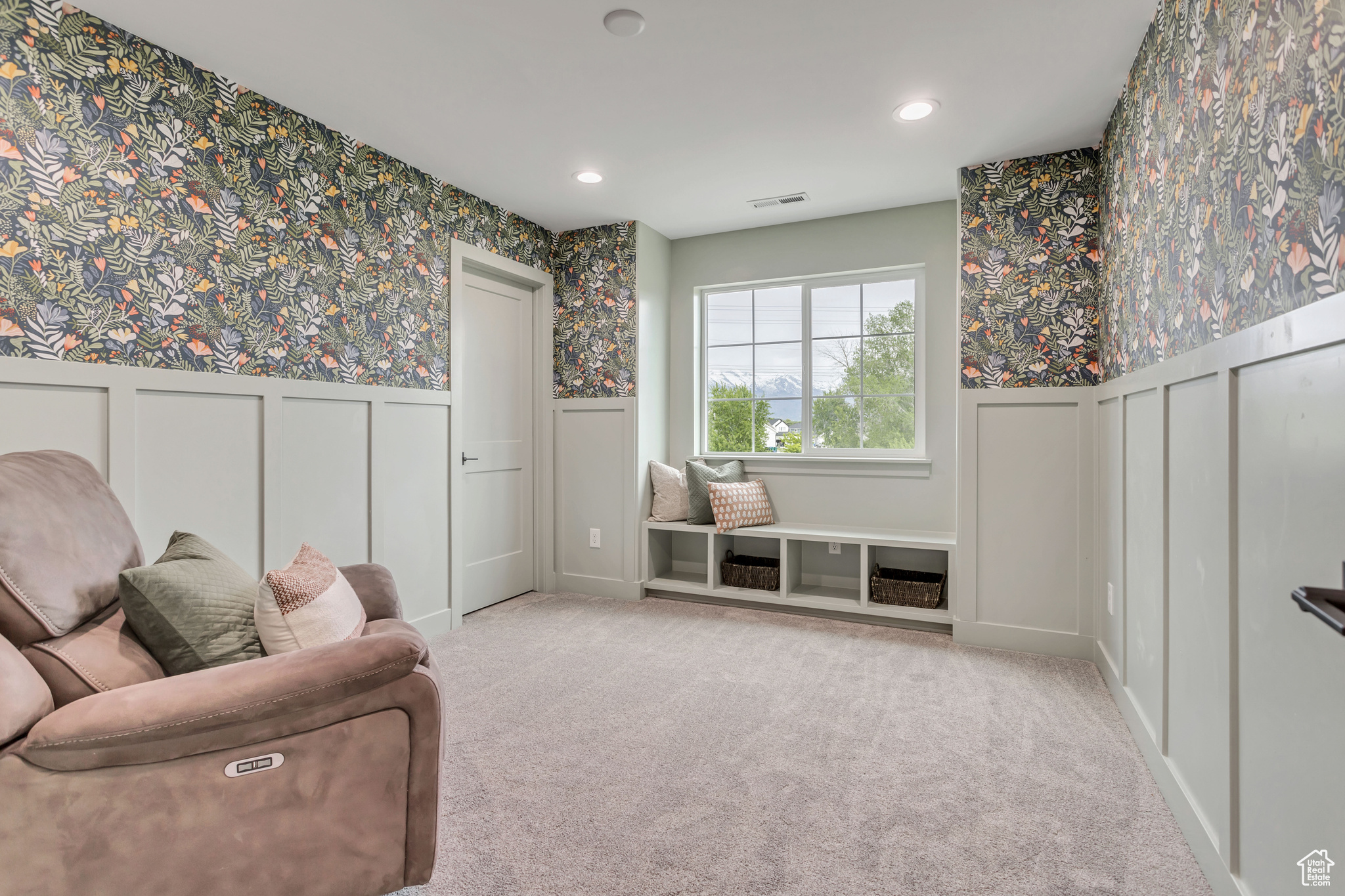 Sitting room/bedroom with light colored carpet and window seat