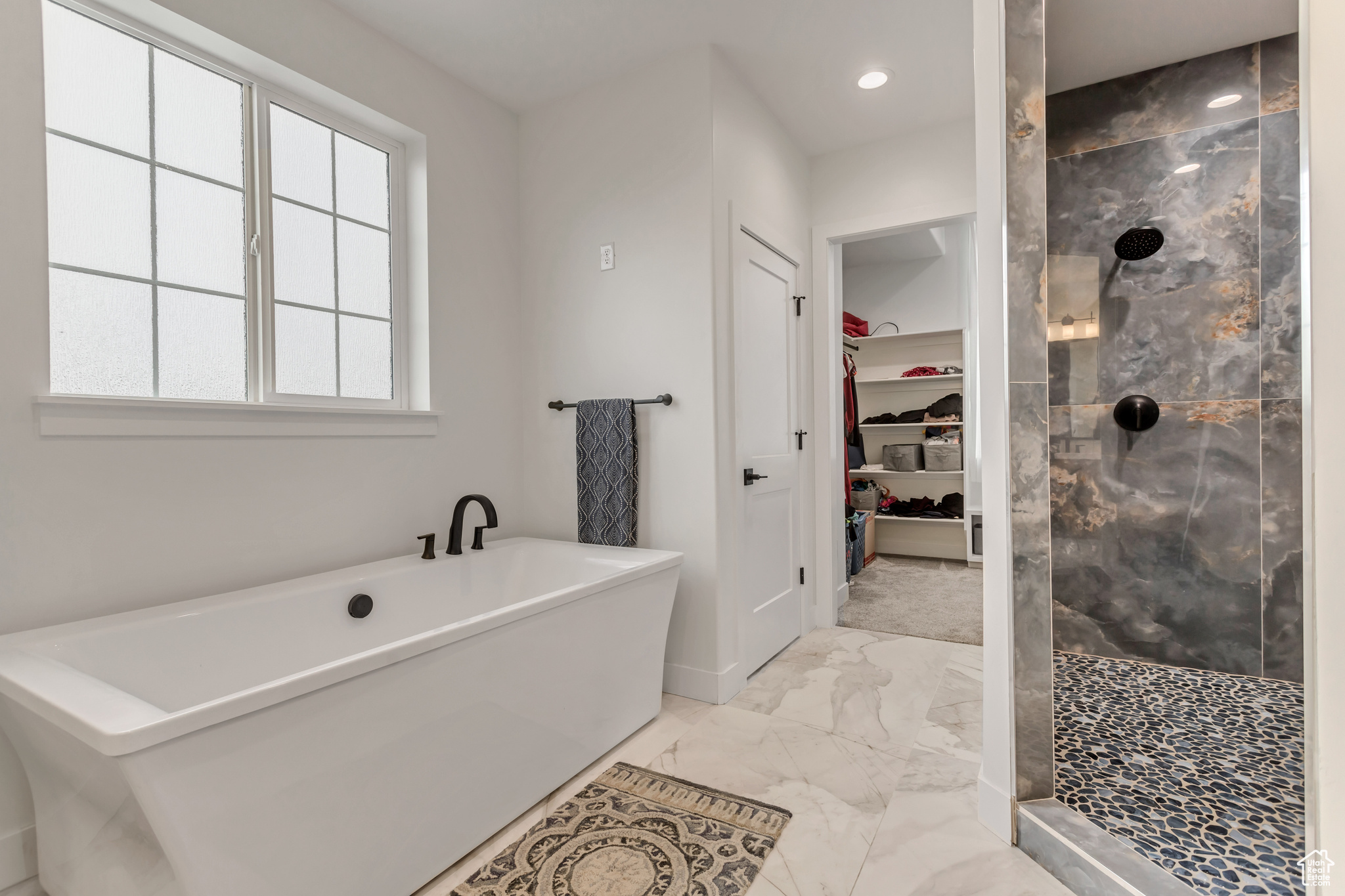 Primary bedroom bathroom featuring a beautiful custom double shower with separate soaking bathtub, walk-in closet and upgraded tile flooring