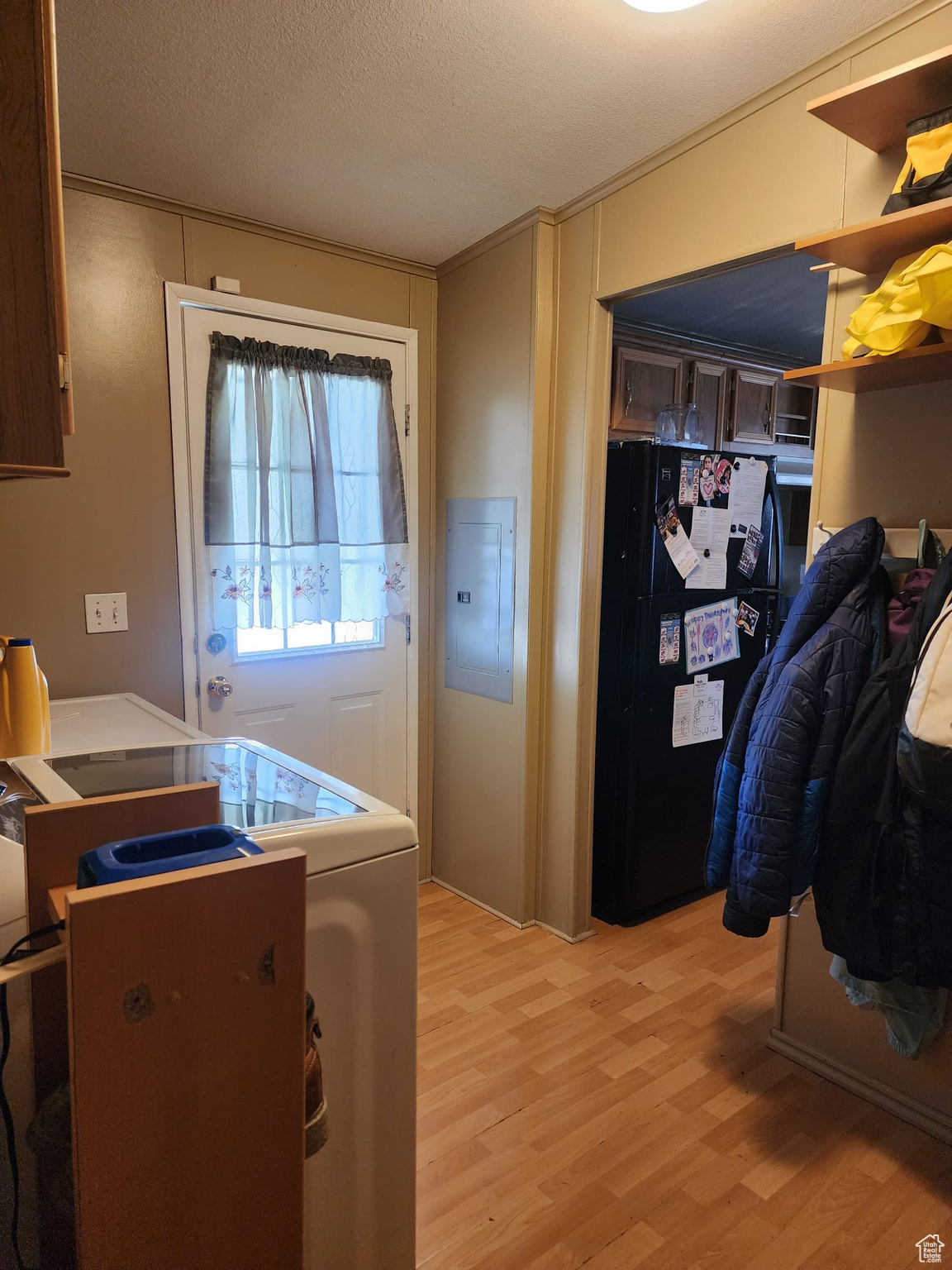 Laundry Room with washer / dryer, a textured ceiling, and light wood-type flooring