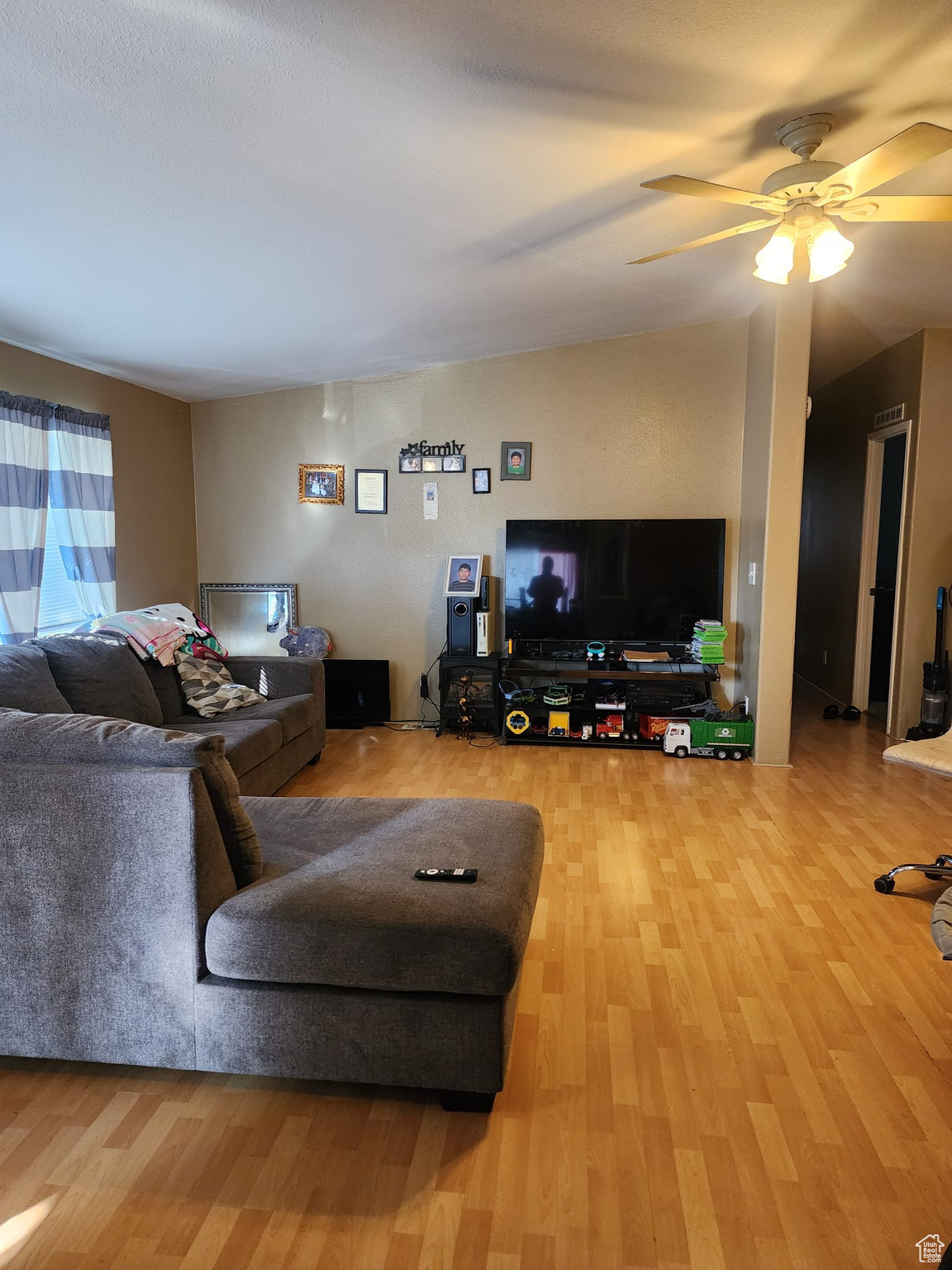 Living room featuring ceiling fan and light wood-type flooring