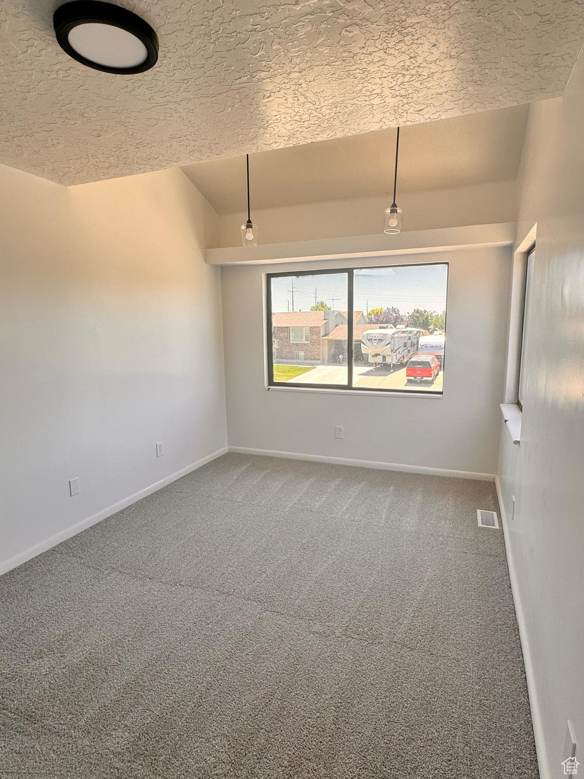 Unfurnished room featuring carpet floors and a textured ceiling