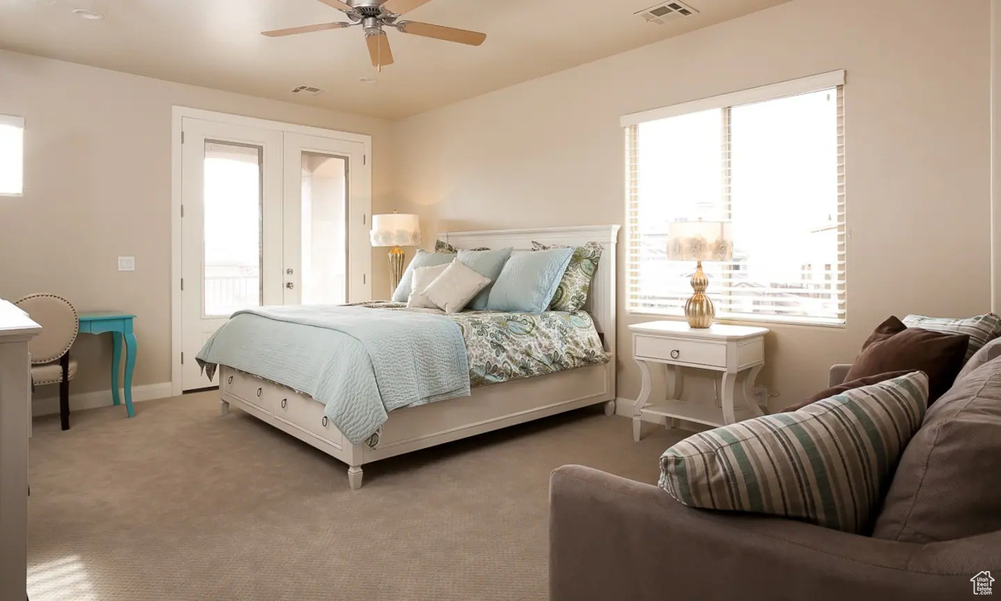 Bedroom featuring carpet, multiple windows, and ceiling fan