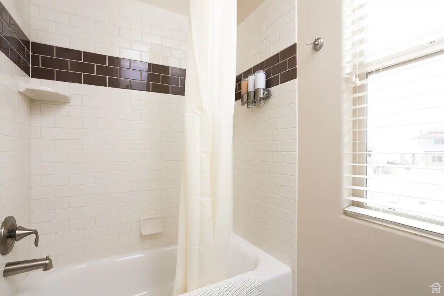 Bathroom featuring a healthy amount of sunlight and shower / bath combo with shower curtain