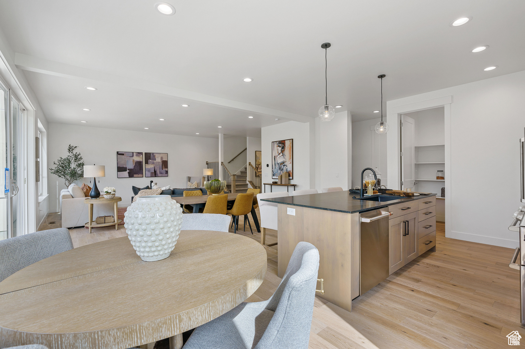 Dining area with built in shelves, sink, and light wood-type flooring