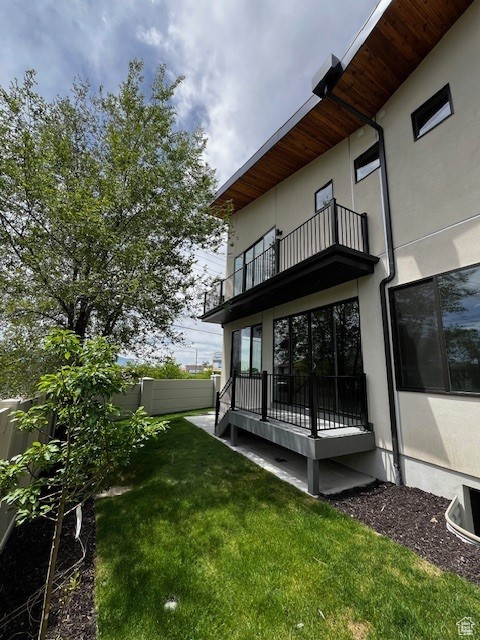 View of rear yard featuring multiple balconies