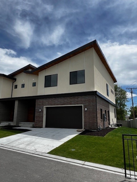 Contemporary home featuring a front lawn and a garage