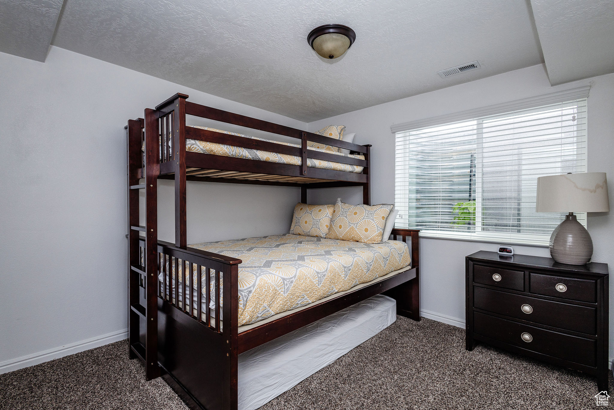 Carpeted bedroom with a textured ceiling