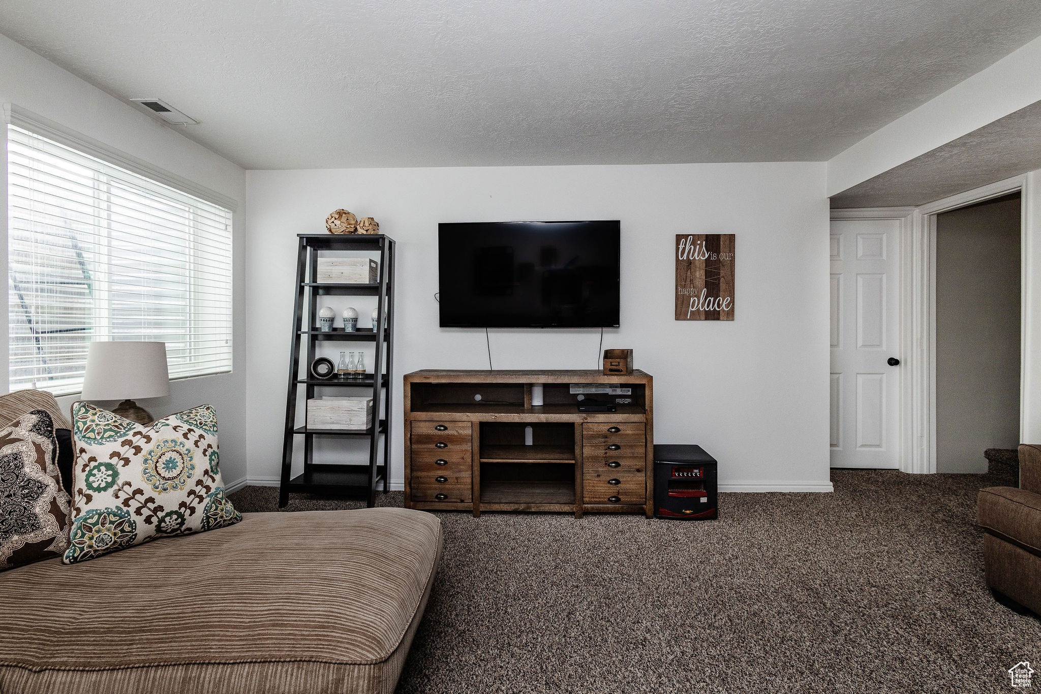 Living room featuring dark carpet and a textured ceiling