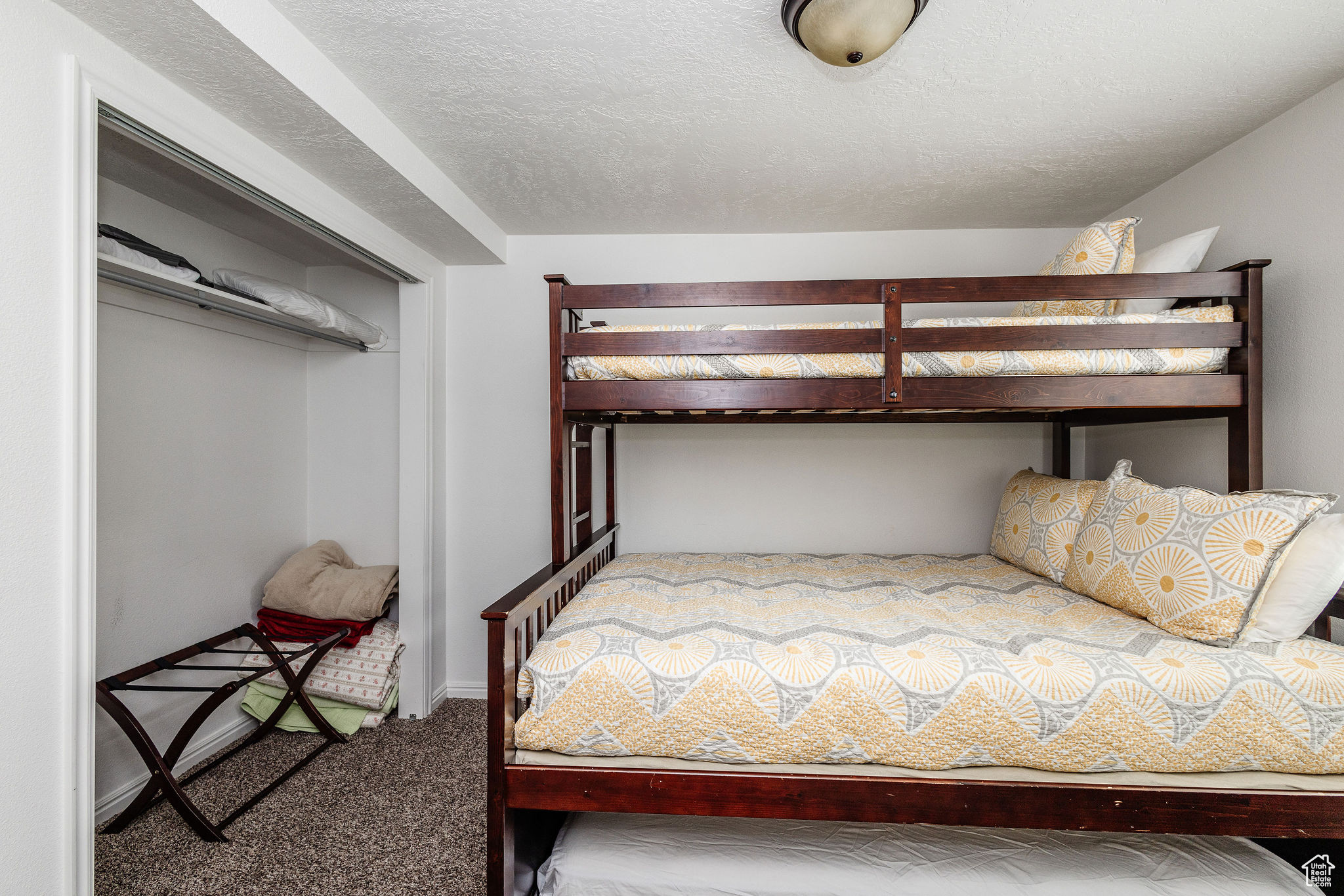 Unfurnished bedroom with a closet, a textured ceiling, and carpet flooring