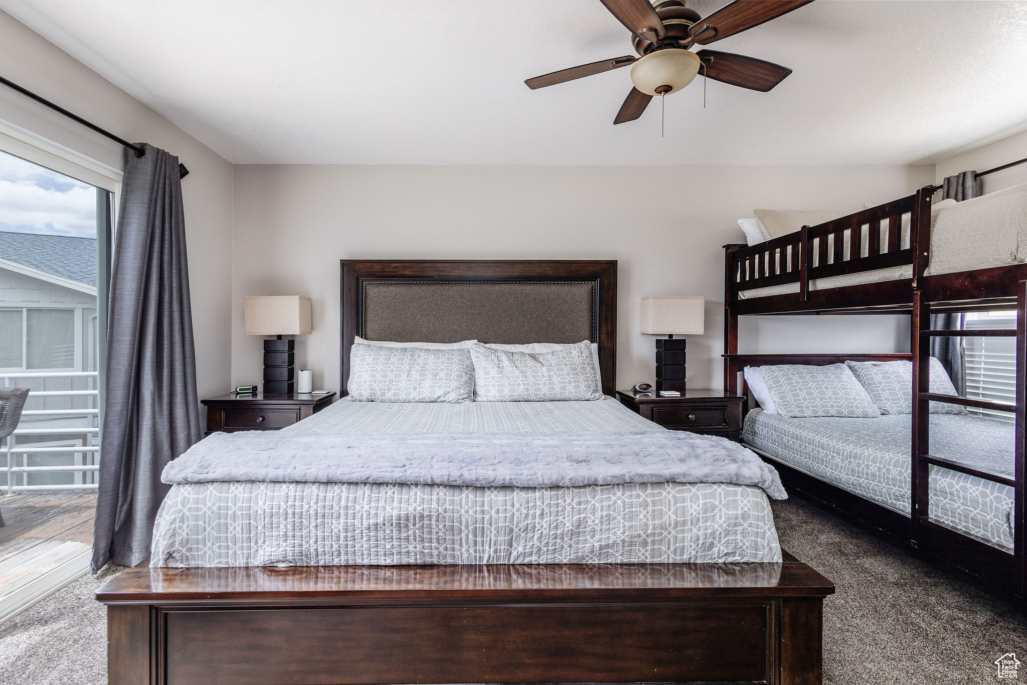 Carpeted bedroom featuring ceiling fan