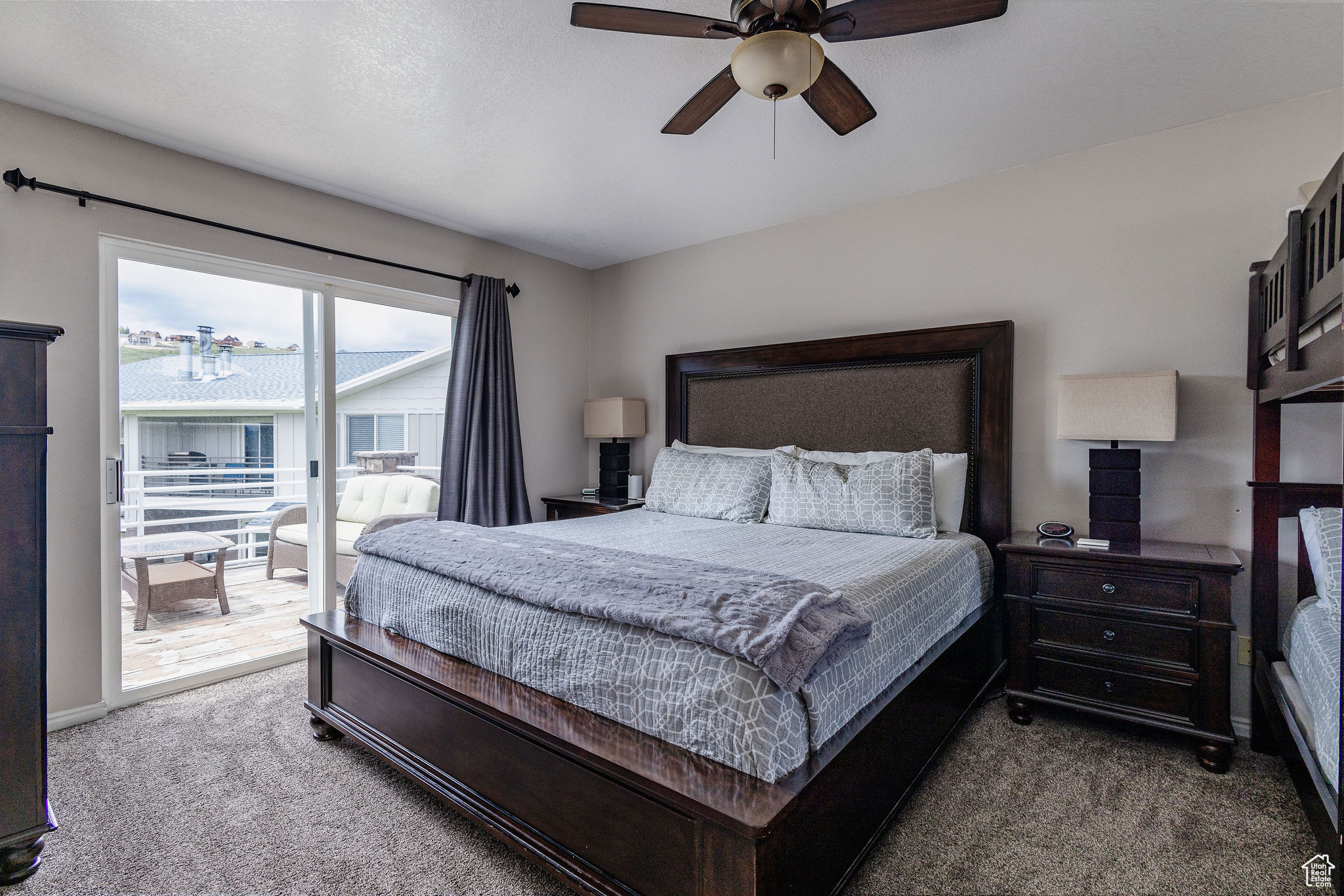 Carpeted bedroom with ceiling fan and access to outside