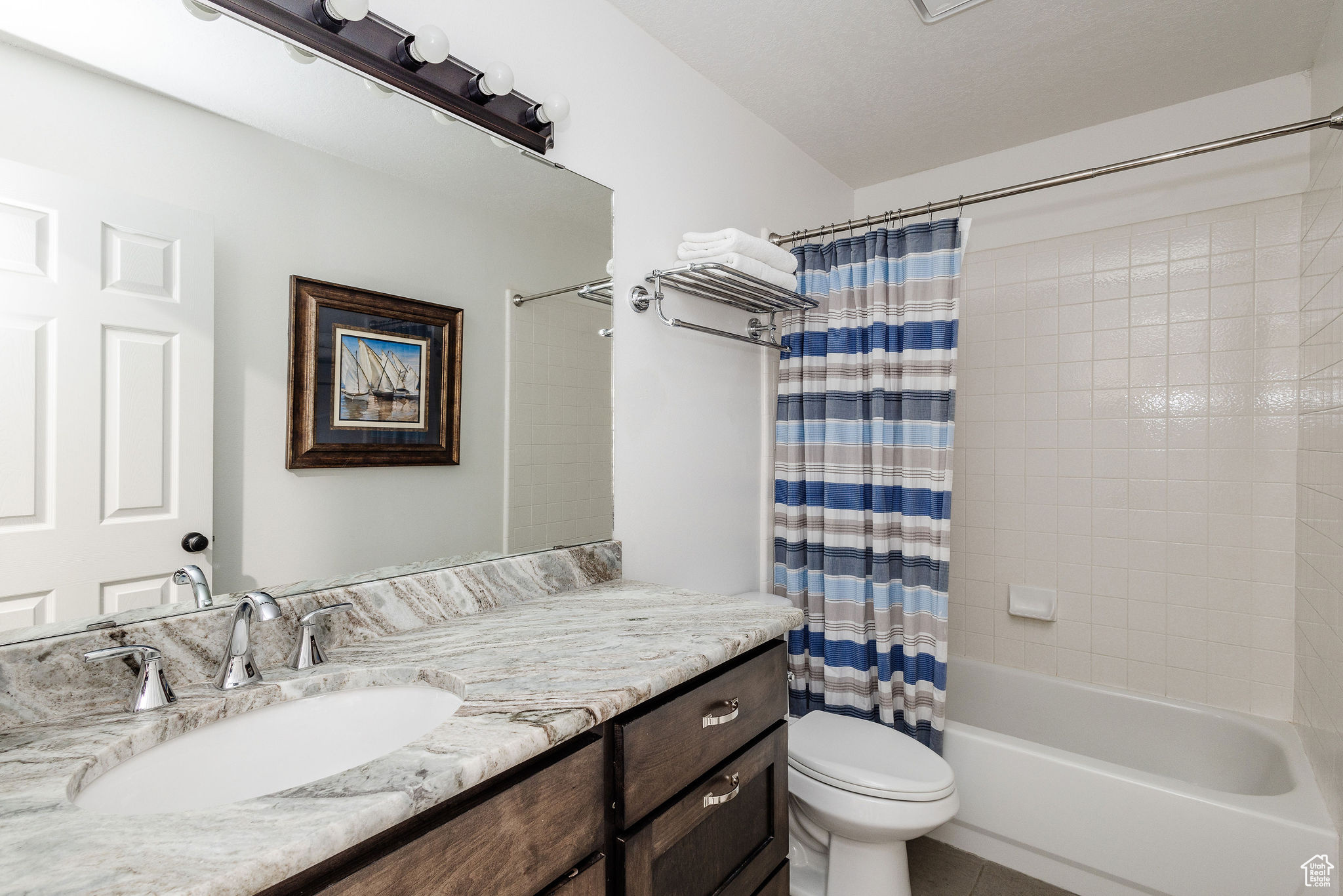 Full bathroom featuring tile flooring, vanity, toilet, and shower / tub combo with curtain