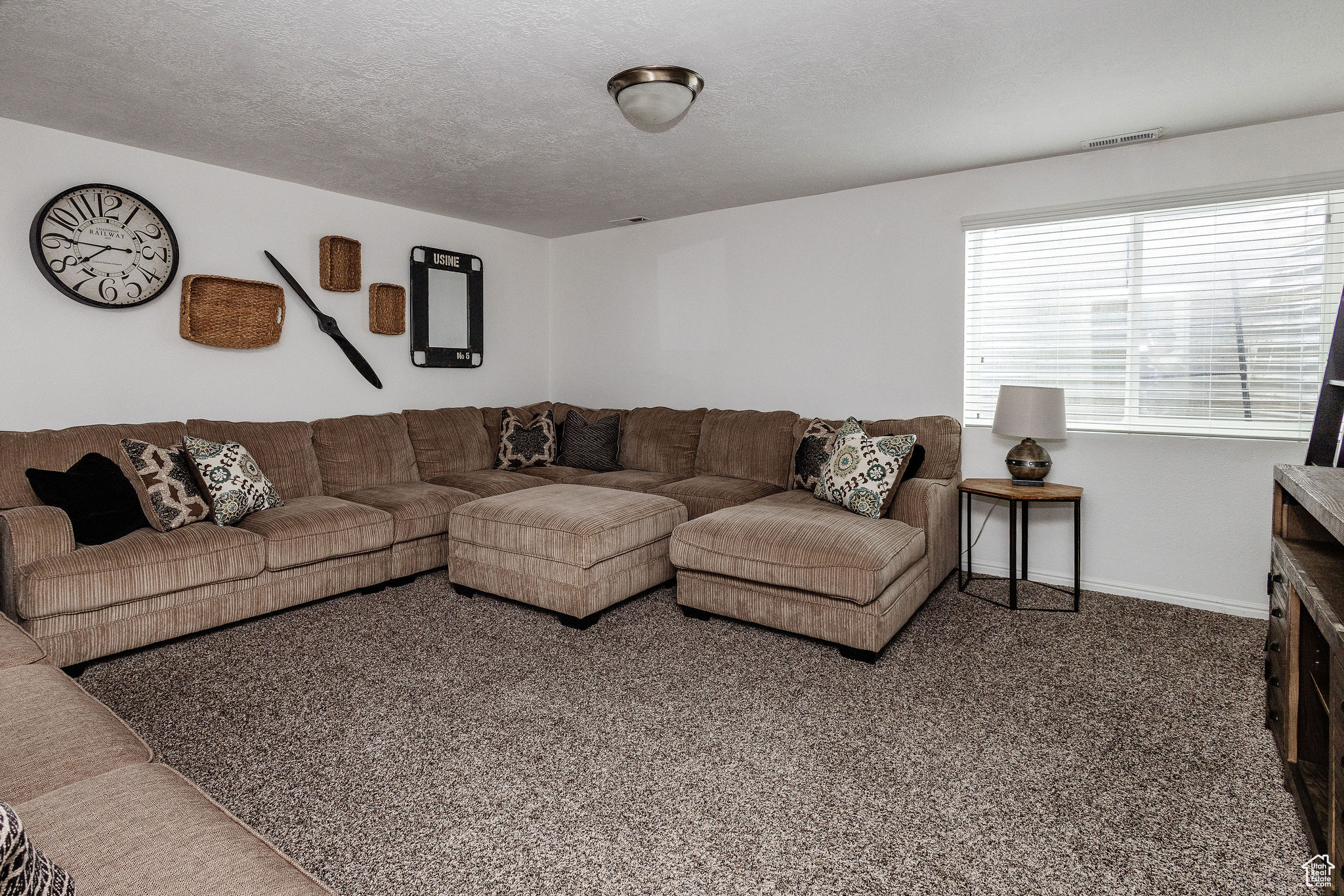 Carpeted living room featuring a textured ceiling