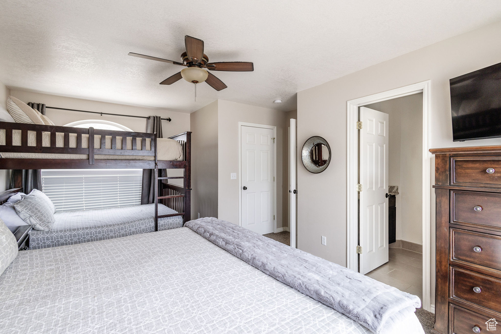 Carpeted bedroom featuring ceiling fan