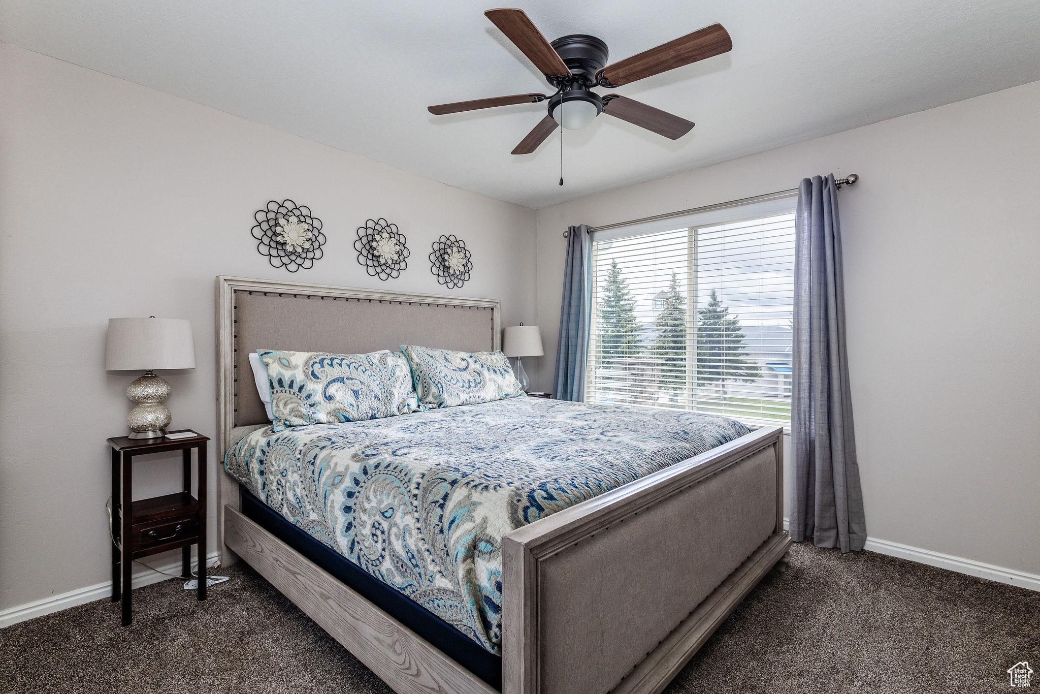 Bedroom featuring ceiling fan and dark carpet