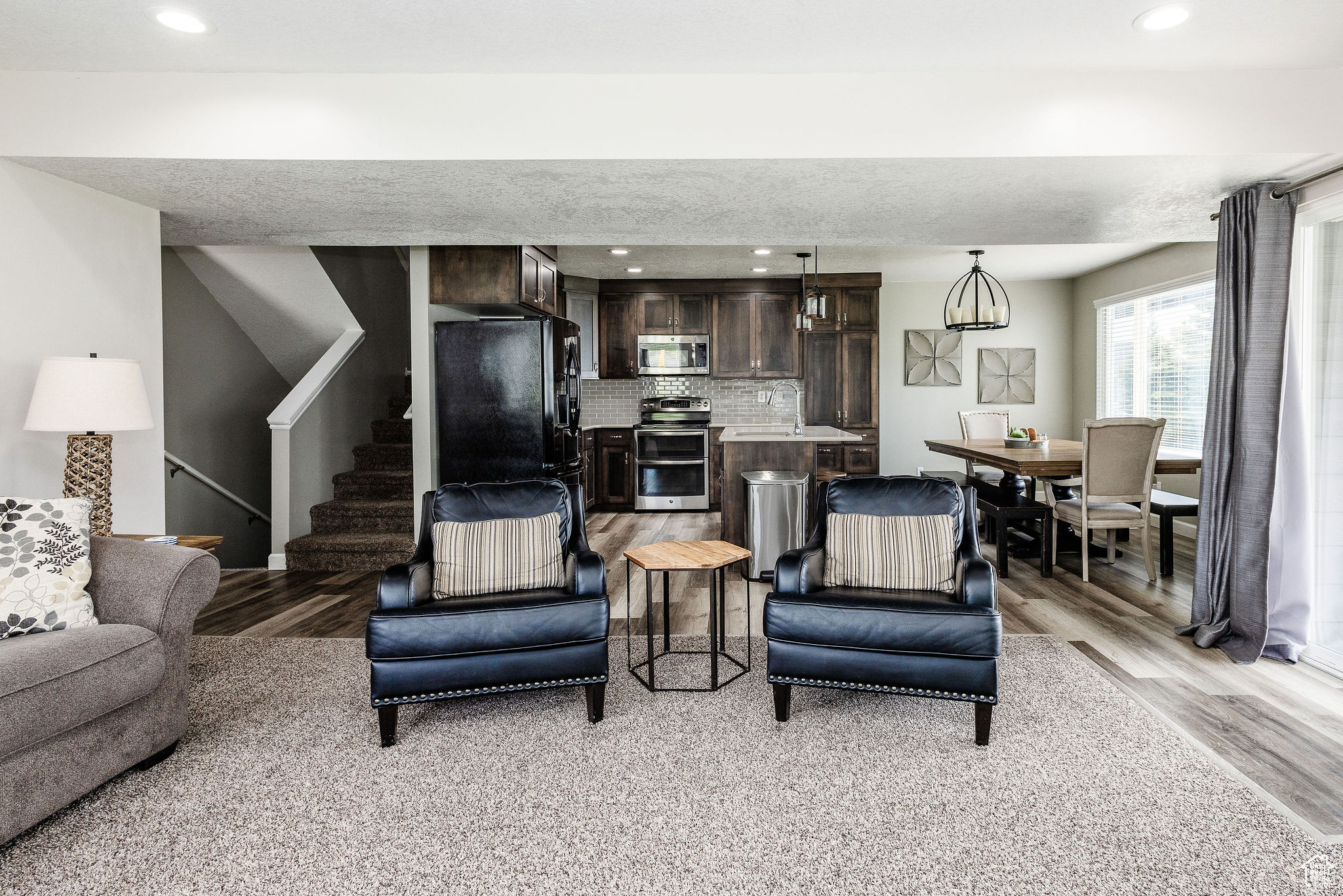 Living room with light hardwood / wood-style flooring and a textured ceiling