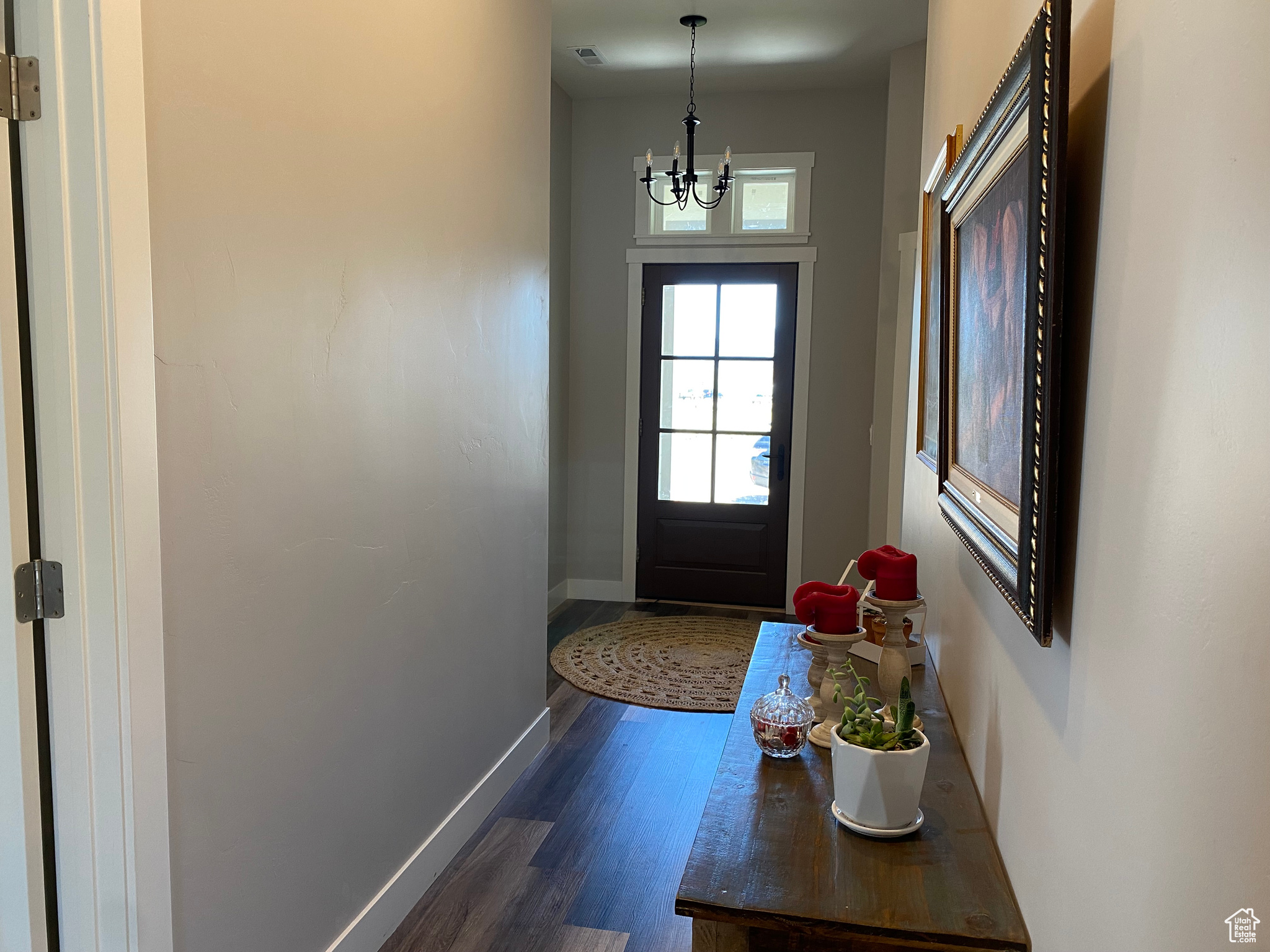 Doorway featuring an inviting chandelier and dark hardwood / wood-style flooring