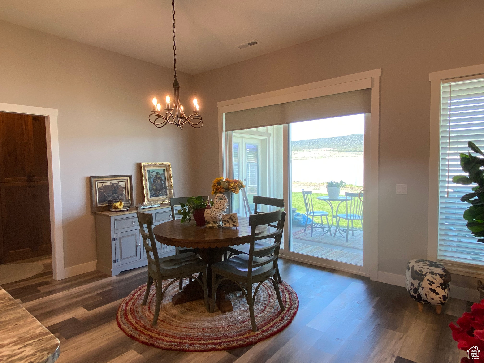 Dining space featuring an inviting chandelier, plenty of natural light, and dark hardwood / wood-style flooring