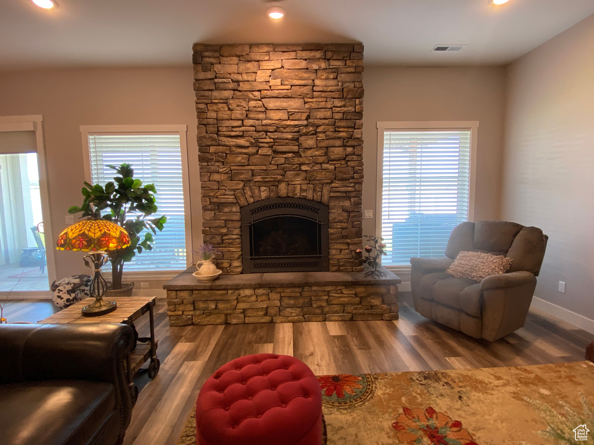 Living room featuring a healthy amount of sunlight, hardwood / wood-style floors, and a fireplace