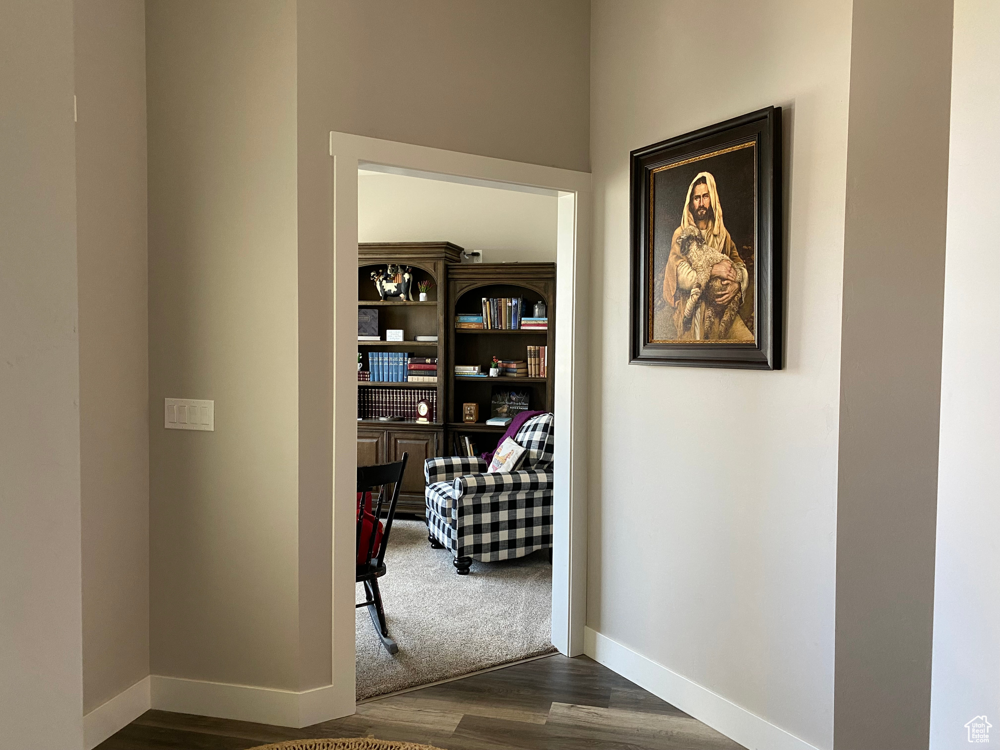 Corridor featuring dark colored carpet