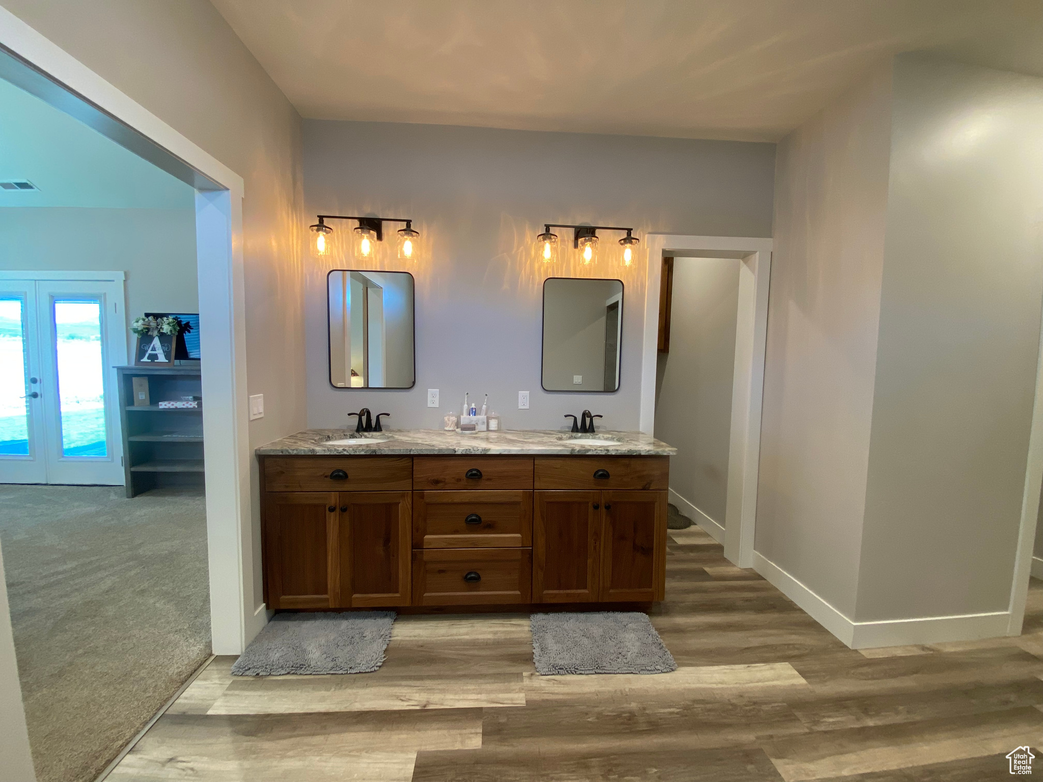 Bathroom with french doors, hardwood / wood-style flooring, and double sink vanity