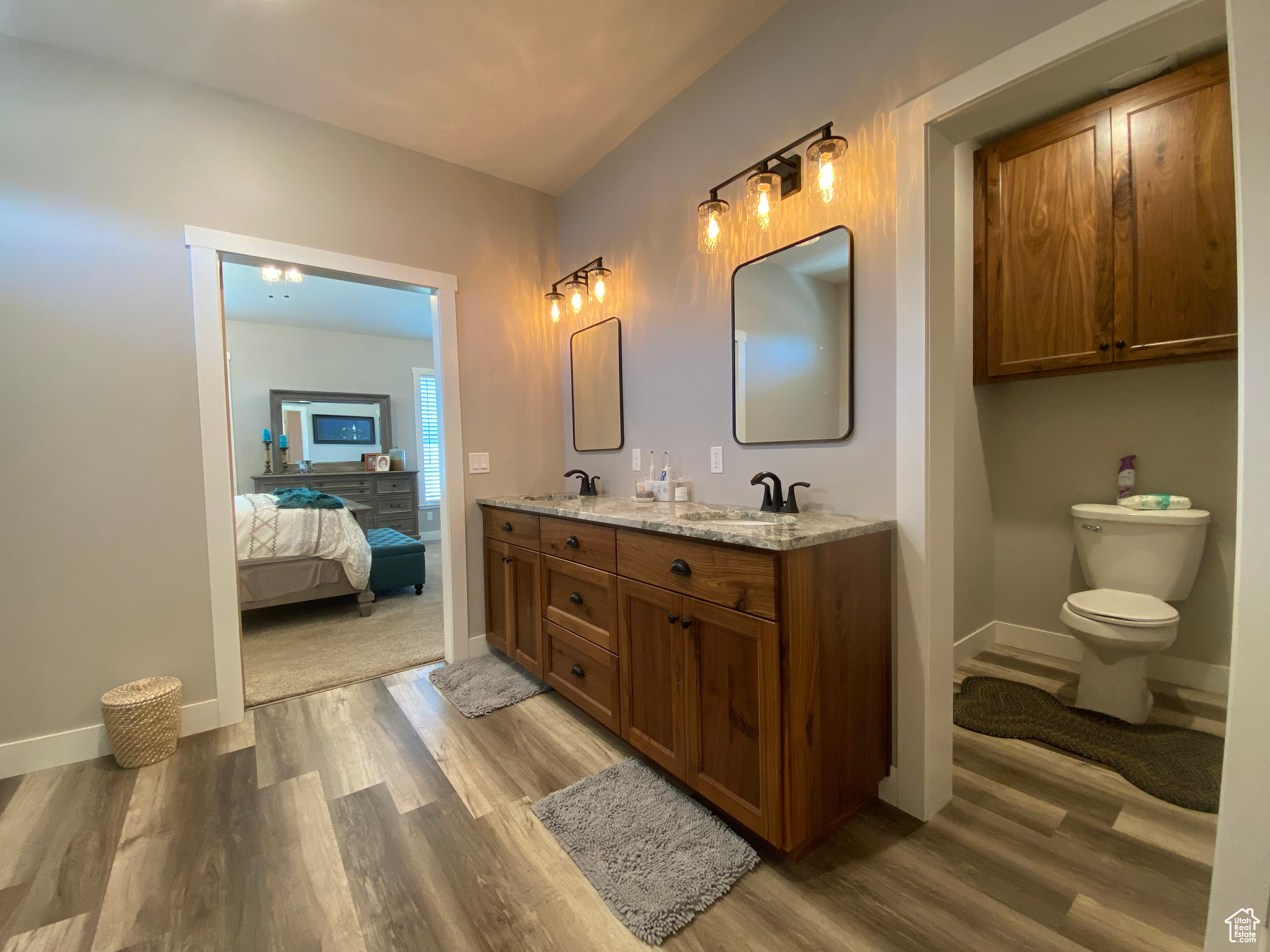 Bathroom featuring hardwood / wood-style floors, double vanity, and toilet