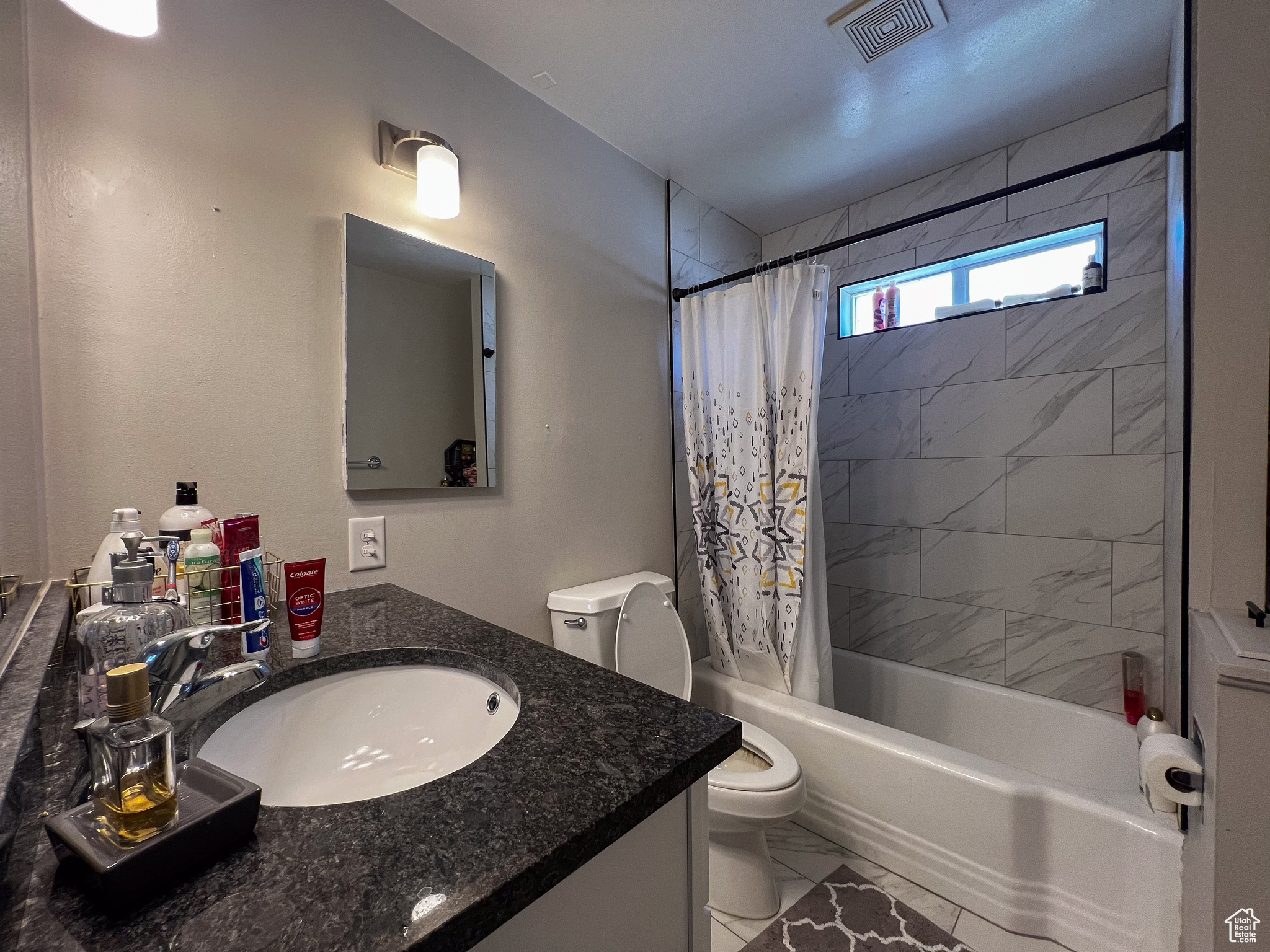 Full bathroom featuring tile flooring, vanity, toilet, and shower / tub combo