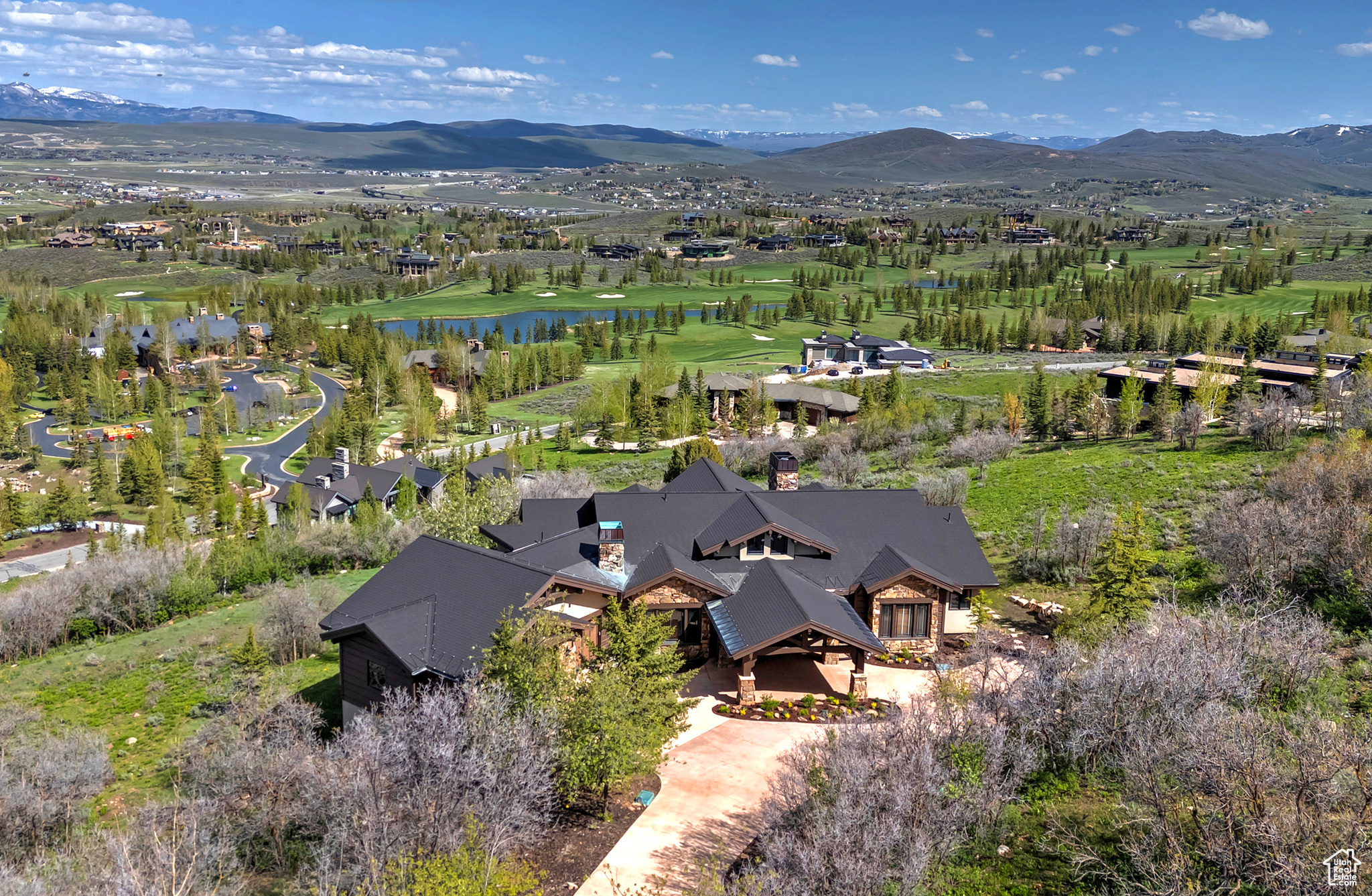 Aerial Drone View Featuring the Golf Course, Pond & Mountains Beyond