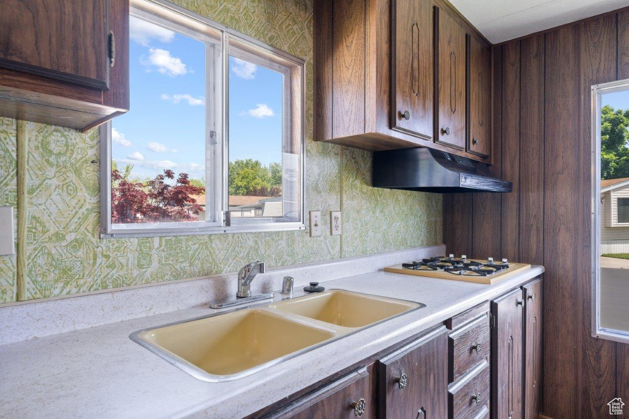 Kitchen featuring dark brown cabinets, sink, and white gas cooktop