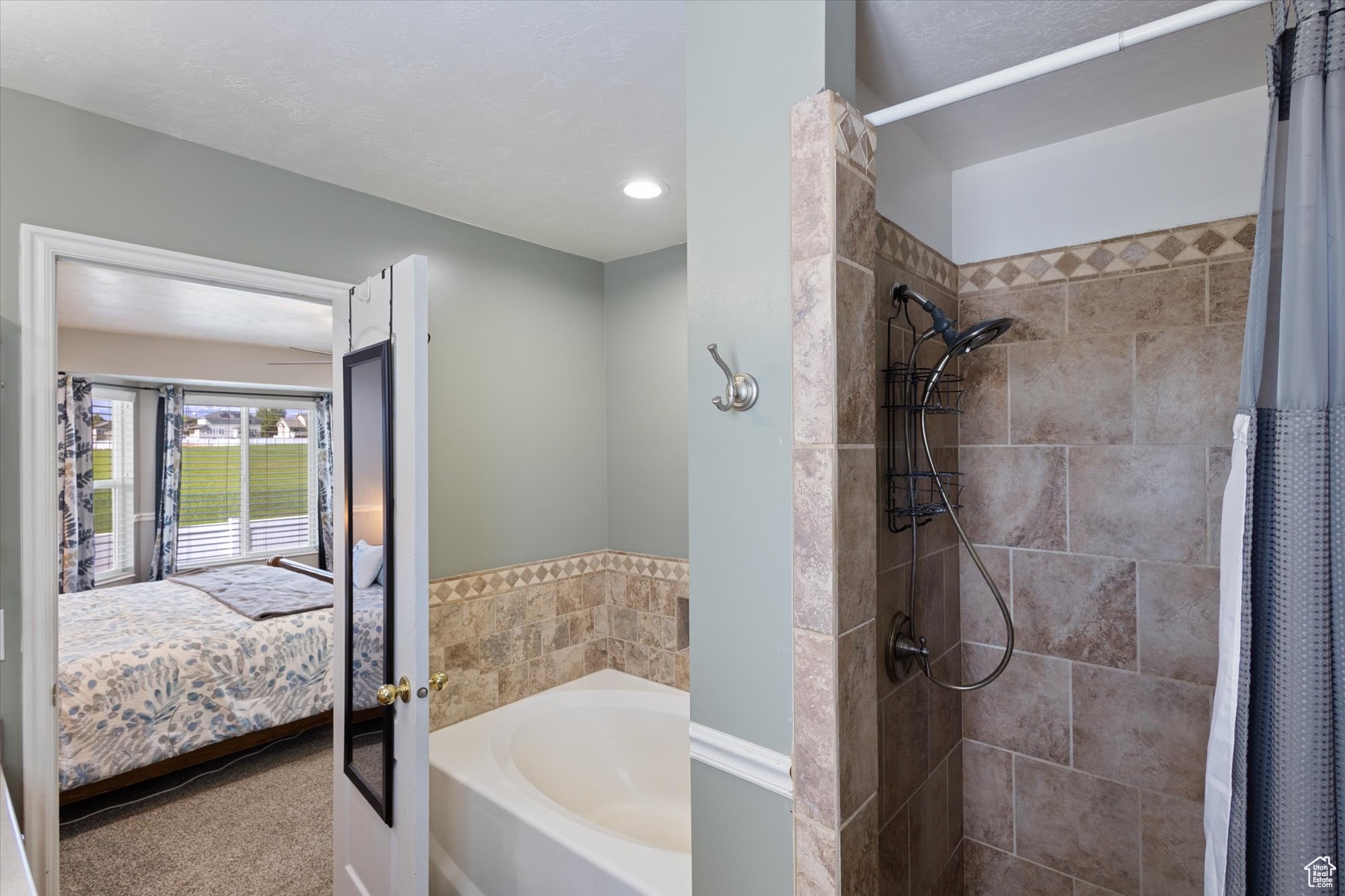 Bathroom with a textured ceiling and separate shower and tub