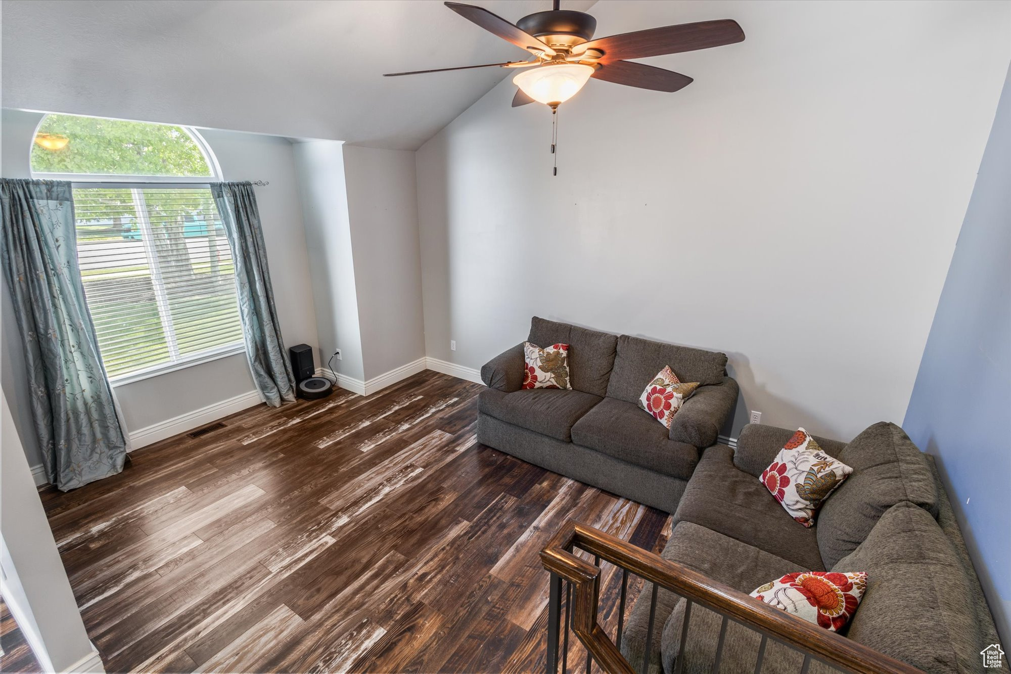 Living room with dark wood-type flooring, ceiling fan, and vaulted ceiling