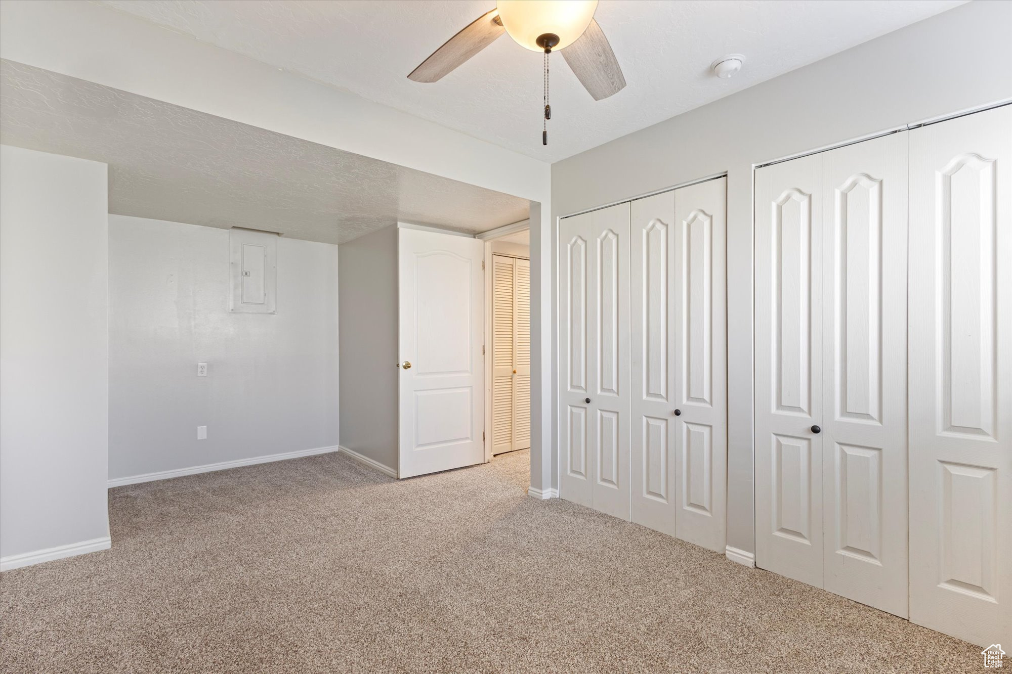 Unfurnished bedroom with multiple closets, carpet, and ceiling fan