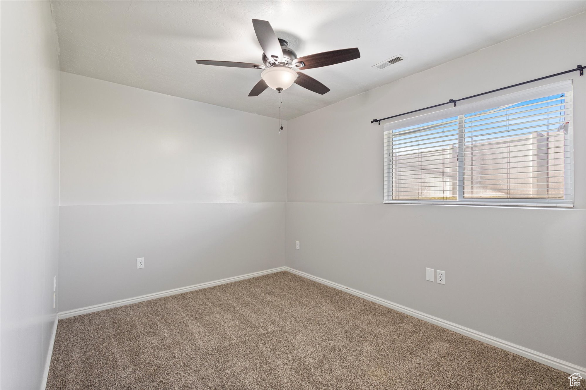 Spare room with ceiling fan and carpet flooring