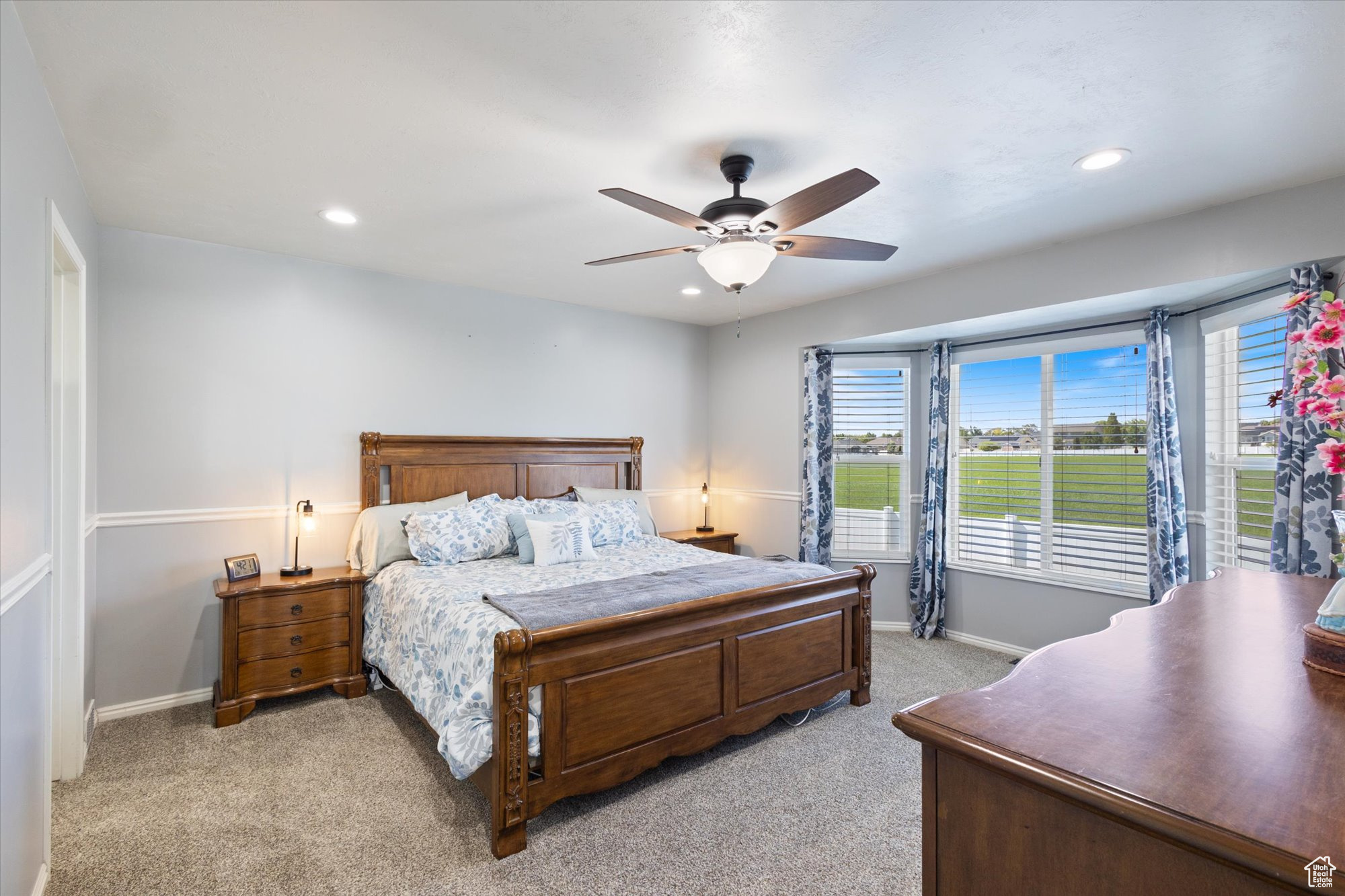 Carpeted bedroom featuring ceiling fan